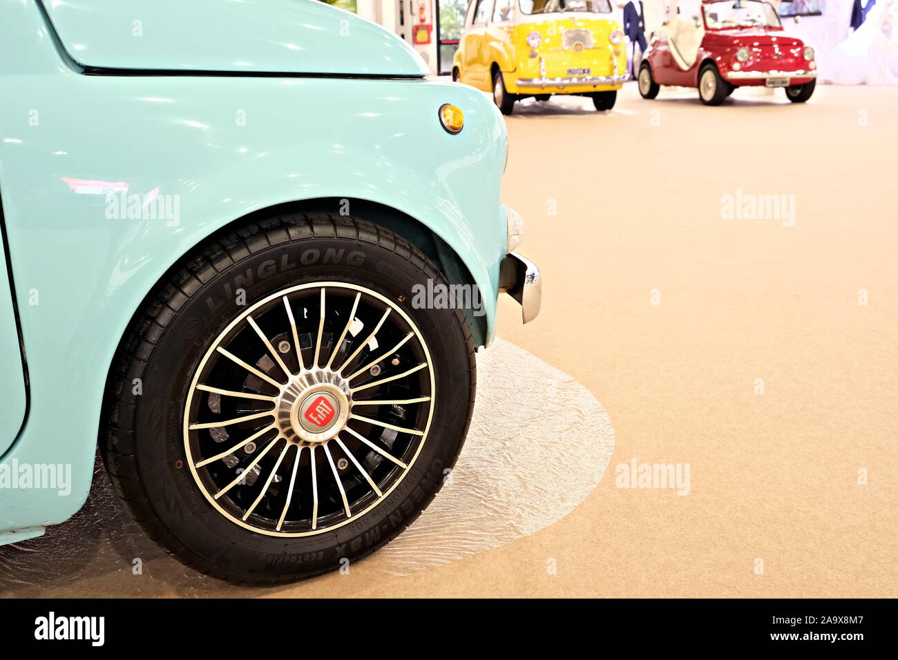 Ansicht schließen eines Rades eines Fiat 500 mit, auf den Hintergrund, andere alten bunten Fiat Autos Stockfoto