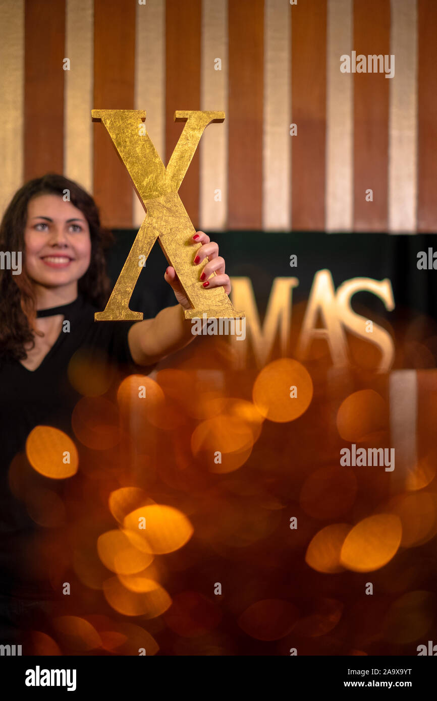 Junge Frau mit dem Buchstaben x des Wortes Xmas Stockfoto