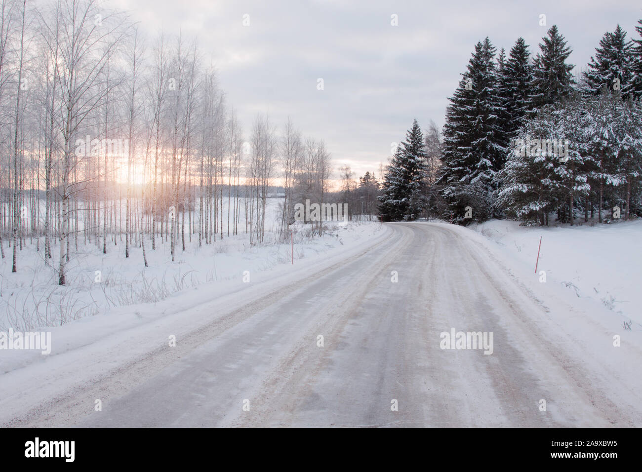 Winterlandschaft mit Frost und Schnee auf den Bäumen. Der Schnee liegt tief neben dem Gepflügt. Salo, Finnland. Stockfoto