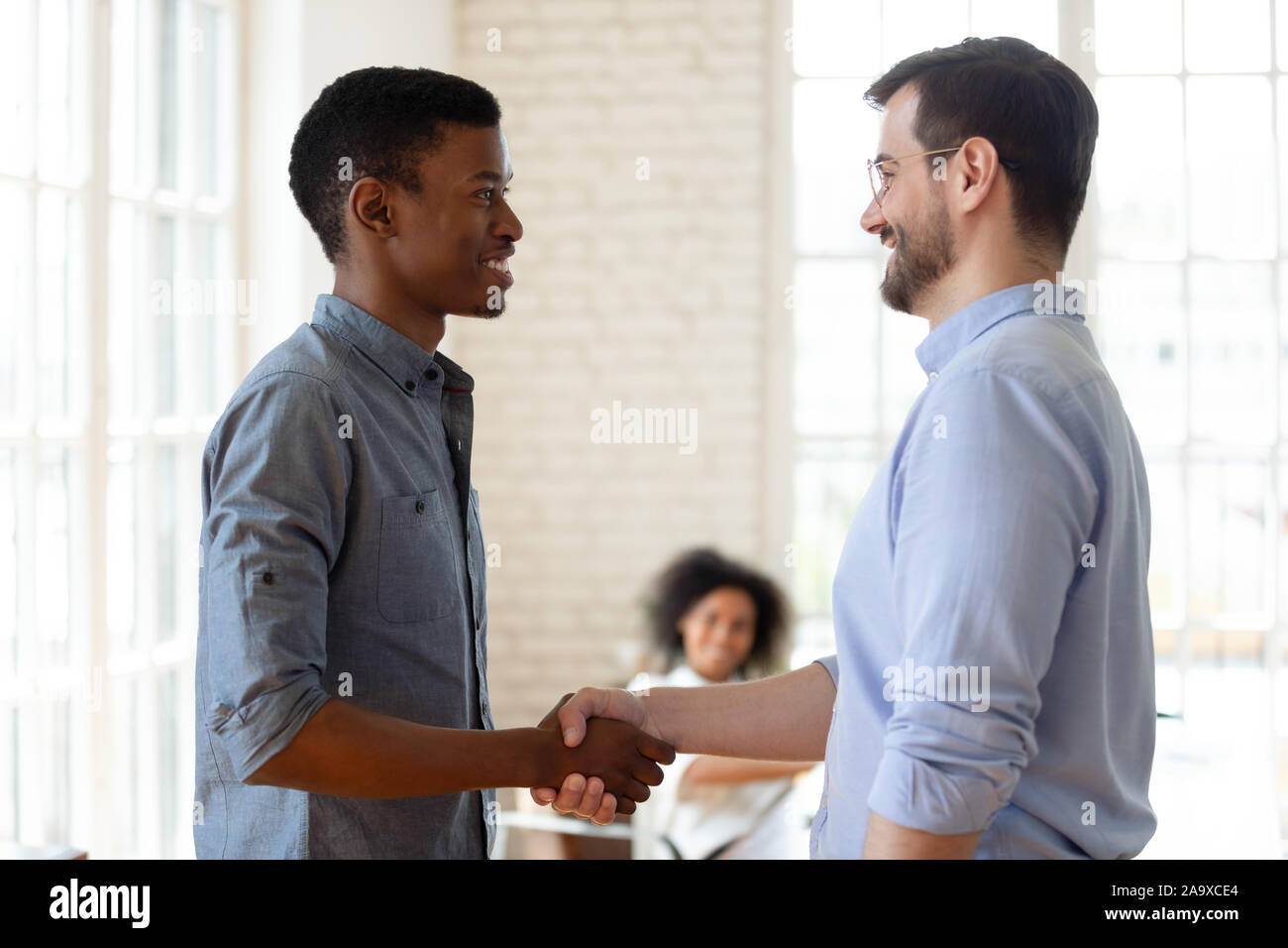 Zuversichtlich leader Händeschütteln mit glücklichen afrikanische amerikanische Mitarbeiter. Stockfoto