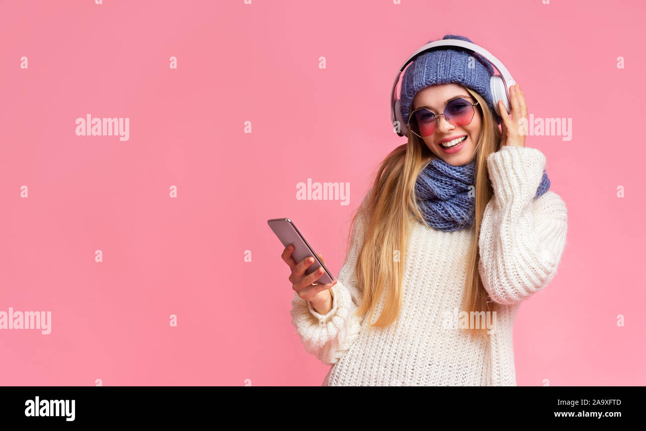 Winter Mädchen Musik hören, über Smartphones und drahtlosen Headsets Stockfoto