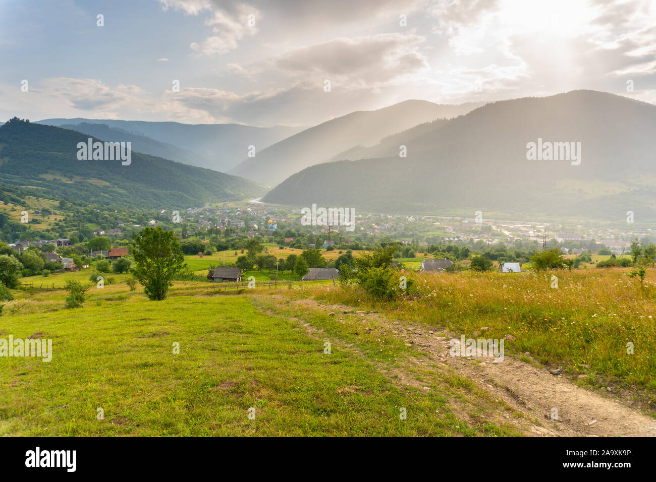 Tolle Aussicht auf Tal und Dorf zwischen Bergen unter Sommer Regen Stockfoto Tolle Aussicht auf Tal und Dorf zwischen Bergen unter Sommer Regen Stockfoto