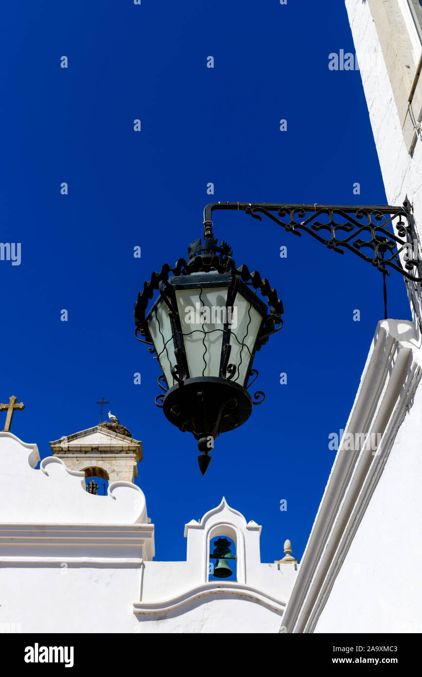 Faro Straßenlaterne, die gegen das Wahrzeichen von Faro, Arco da vila, und den klaren blauen Himmel, Faro Algarve Portugal, gerahmt ist Stockfoto