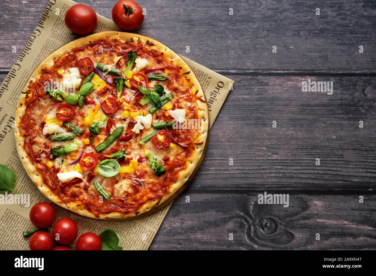 Blick von oben auf die vegetarische Pizza serviert auf rustikalen Holztisch Stockfoto