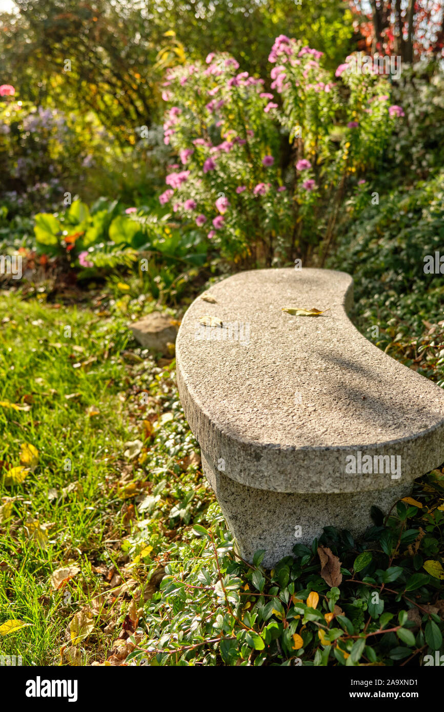 Steinbank an einem sonnigen Tag in einem herbstlichen Garten mit blühenden  Blumen, Pflanzen und Bäume. In Franken/Bayern, Deutschland im Oktober  gesehen Stockfotografie - Alamy