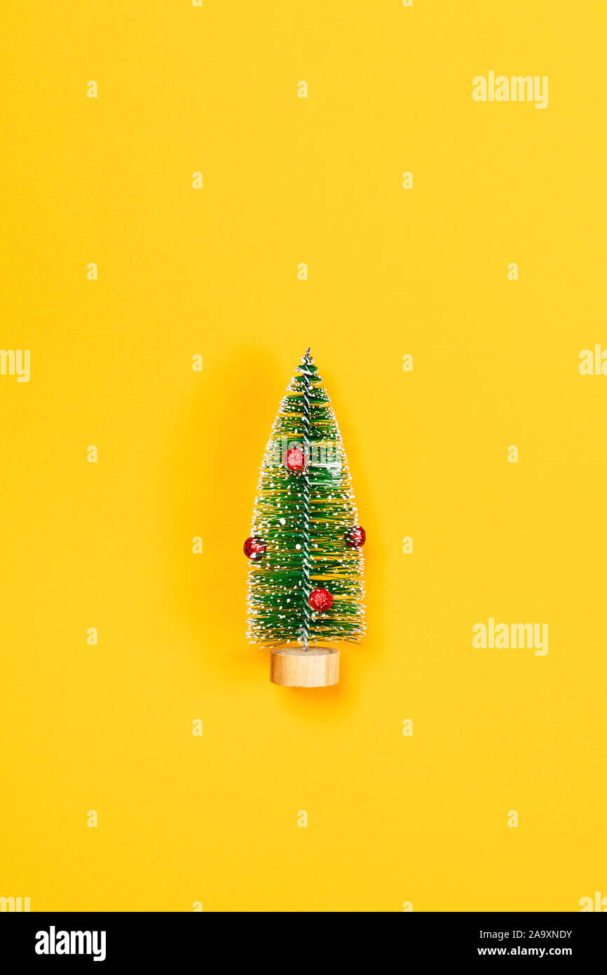 Weihnachten und neues Jahr gelb dekorative Hintergrund mit einem Weihnachtsbaum. Flach, Ansicht von oben, kopieren. Stockfoto