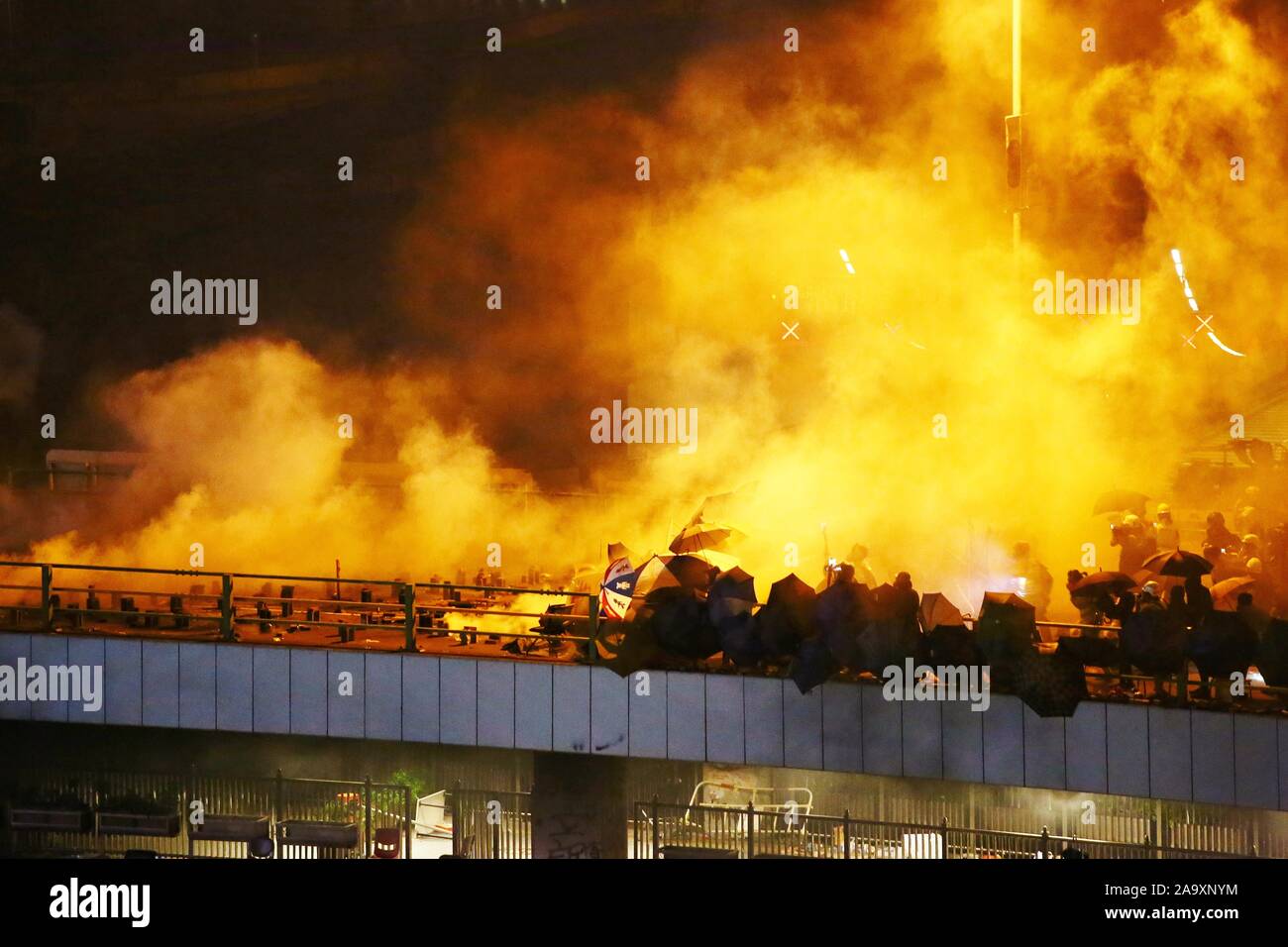 Hongkong, China. 17. Nov, 2019. Demonstranten in Brand gesetzt. Der Eingang der Hong Kong Polytechnic University Bereitschaftspolizei aus der Eingabe zu beenden. Hier Demonstranten und Polizei Zusammentreffen auf einer Brücke, die den Campus an der Hong Kong Polytechnic University auf Sonntag Nacht. Credit: Gonzales Foto/Alamy leben Nachrichten Stockfoto