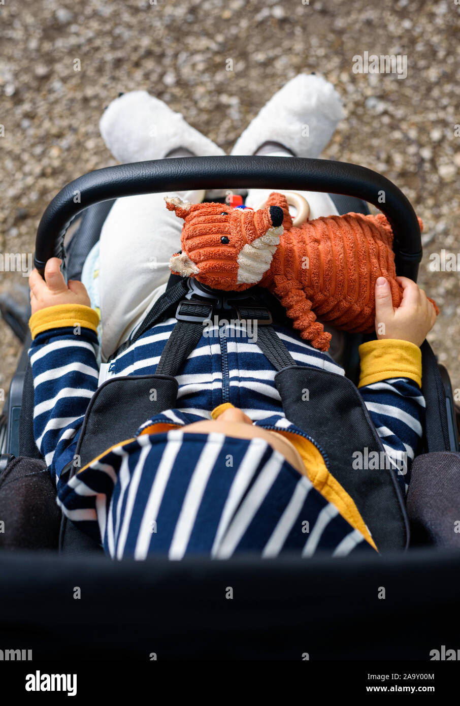 Kaukasische Baby im Kinderwagen sitzen und ein Kuscheltier. Stockfoto