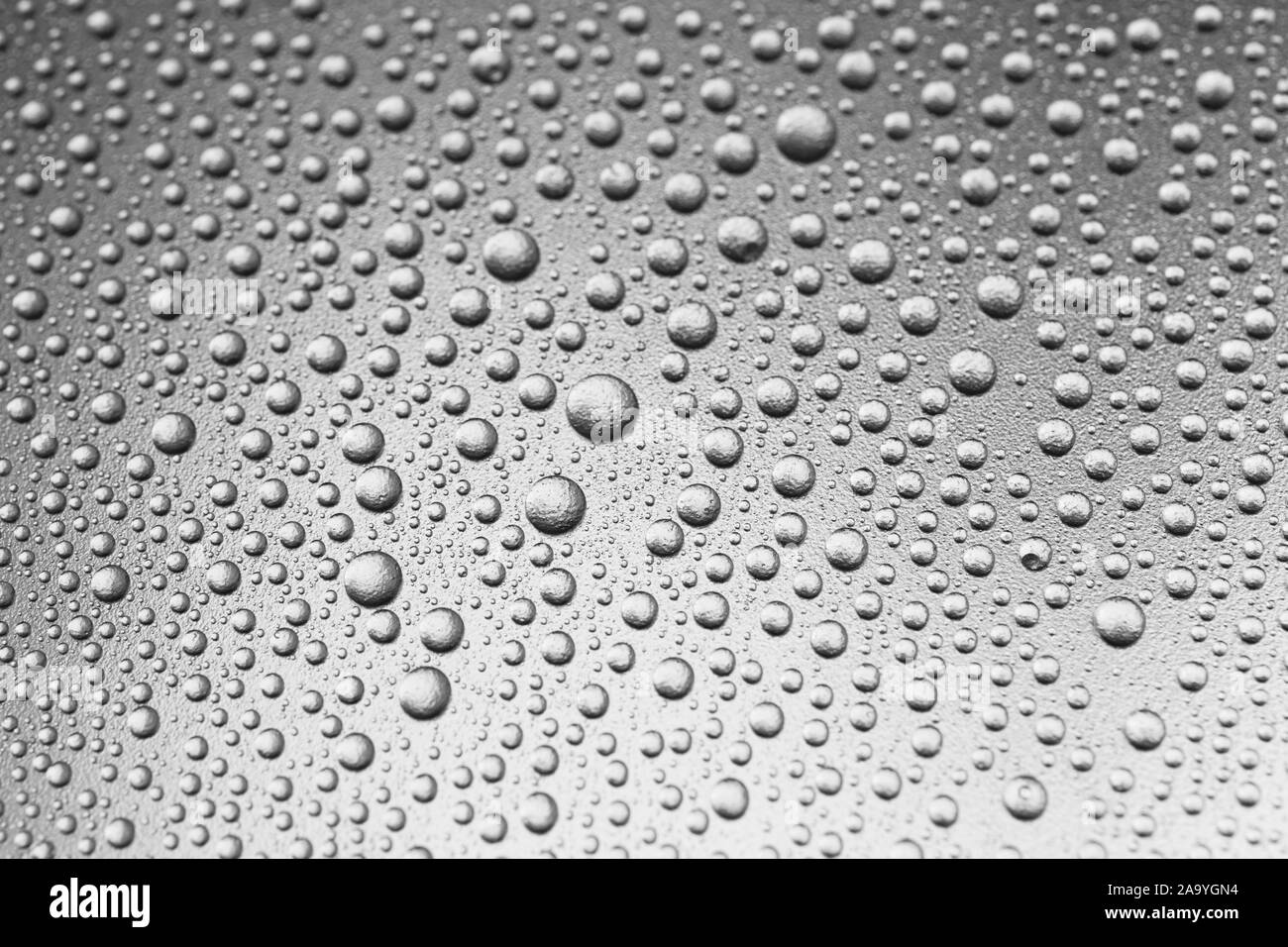Hintergrund der leuchtenden Wassertropfen auf Silbrige Oberfläche, Makro Stockfoto