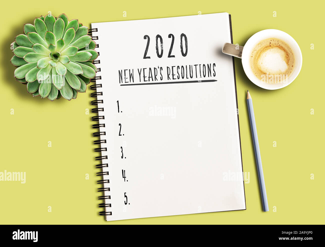 Blick von oben auf die merkliste mit Text 2020 Neue Jahre Auflösungen und nummerierte Liste auf gelb Schreibtisch mit sukkulenten Pflanzen- und Tasse Kaffee Stockfoto