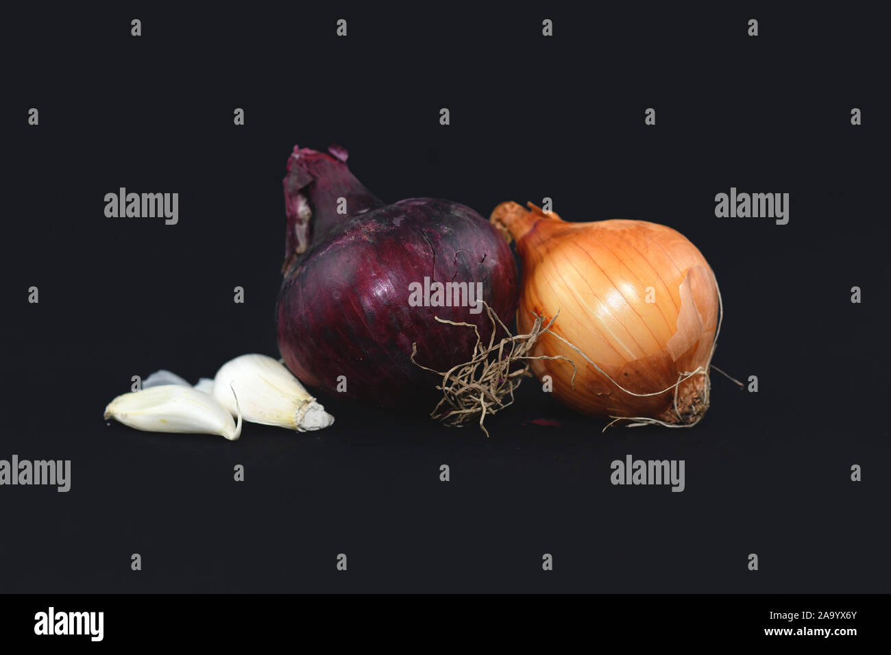 Mischung der verschiedenen Gemeinsamen gelbe und rote Zwiebel Zwiebeln und Knoblauch weiß auf schwarzem Hintergrund Stockfoto