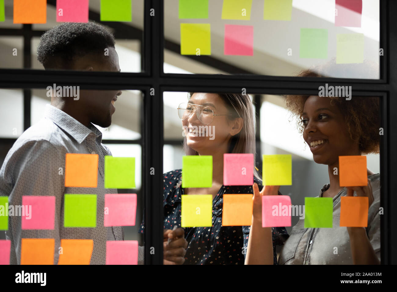 Lächelnde Angestellte mit der Verwendung von Verwaltungstools für die Arbeitsplanung. Stockfoto