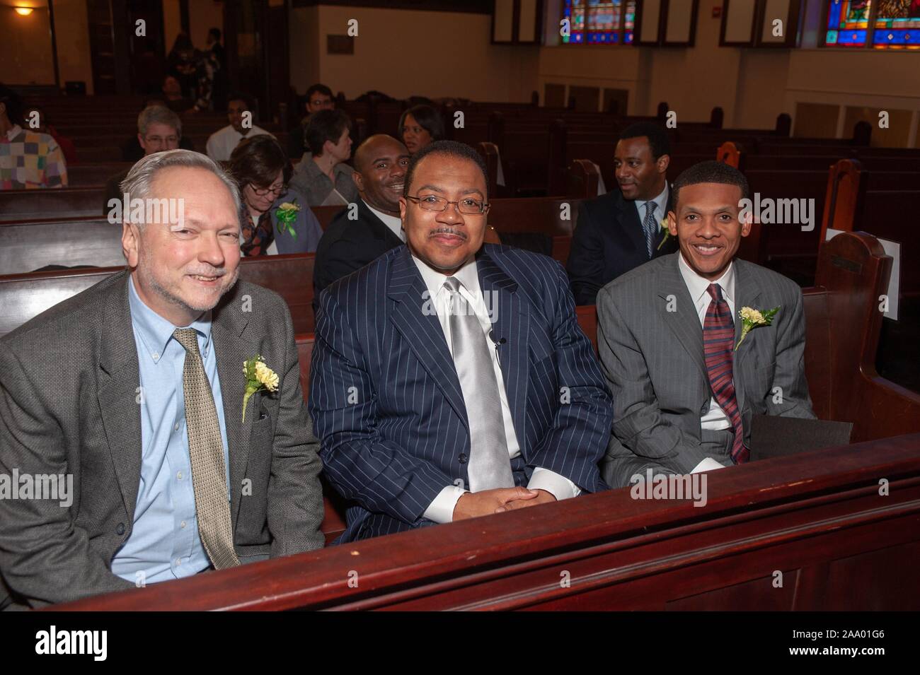 Leicht schräg aus drei Personen, in die Kamera lächeln, während er sich in einer Kirchenbank am Bunting-Meyerhoff Interfaith Center sitzen, während eines Martin Luther King Einberufung Ereignis durch das Amt für multikulturelle Angelegenheiten an der Johns Hopkins Universität, Baltimore, Maryland, 19. Februar 2009 vorgestellt. Vom Homewood Sammlung Fotografie. () Stockfoto