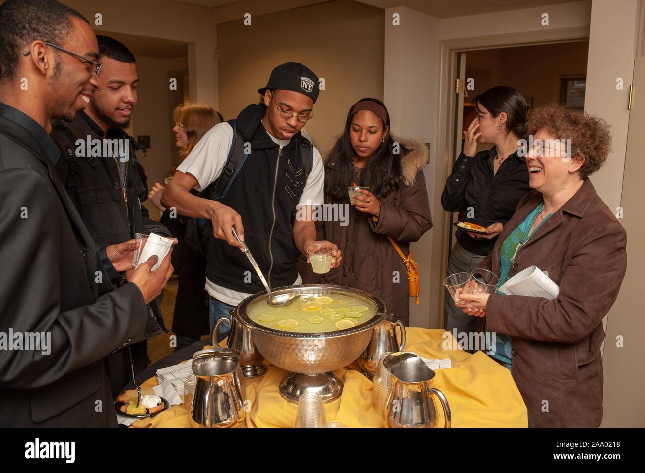 Eine Person, die Pfannen einen Drink in eine Schale, als lächelnd Kollegen wiederum während einer Funktion warten feiert die Eröffnung der Multikulturelle Angelegenheiten Student Center an der Johns Hopkins Universität, Baltimore, Maryland, 27. Februar 2009. Vom Homewood Sammlung Fotografie. () Stockfoto