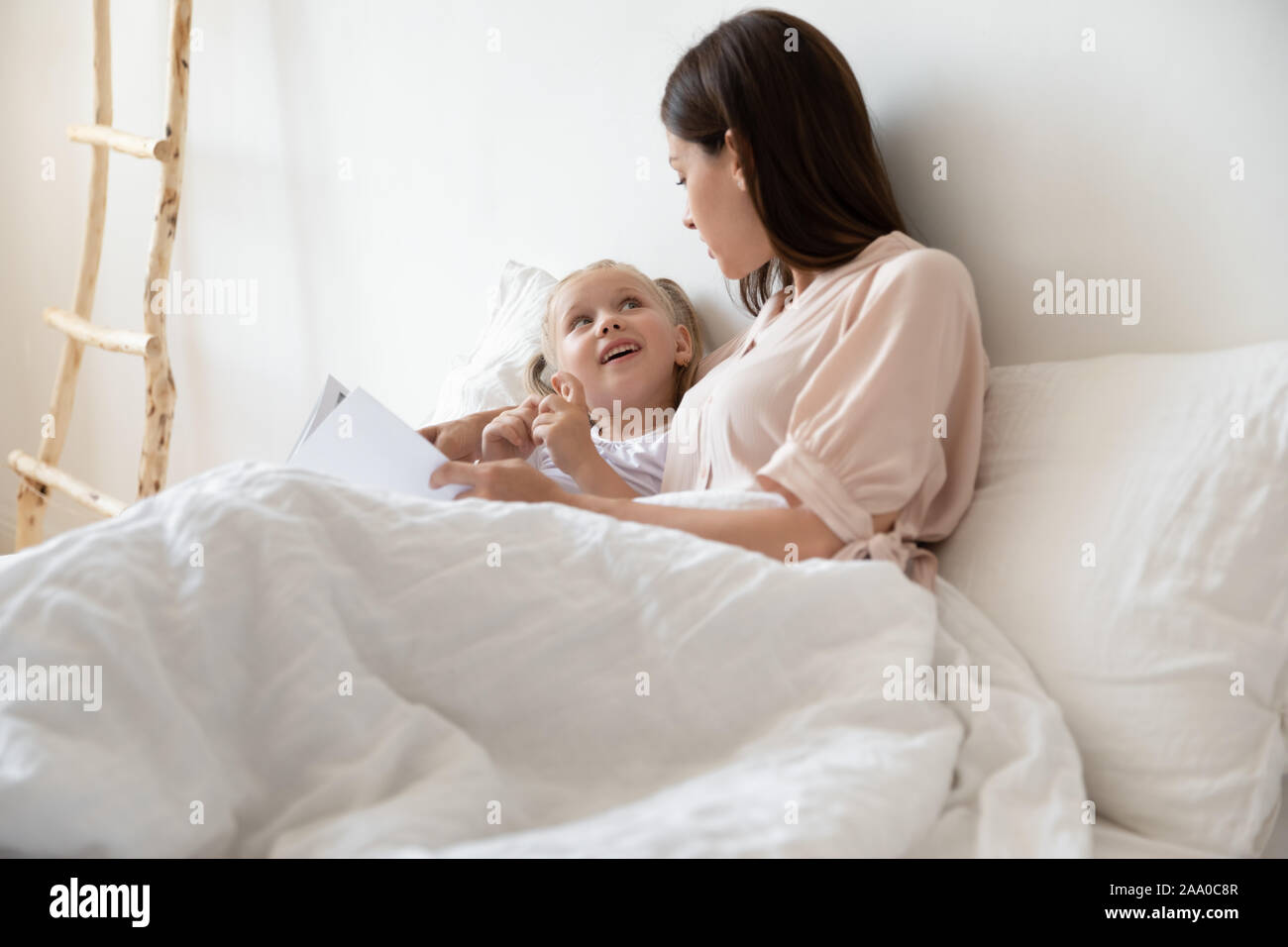 Glückliche Familie von zwei entspannende im Bett, Buch zu lesen. Stockfoto