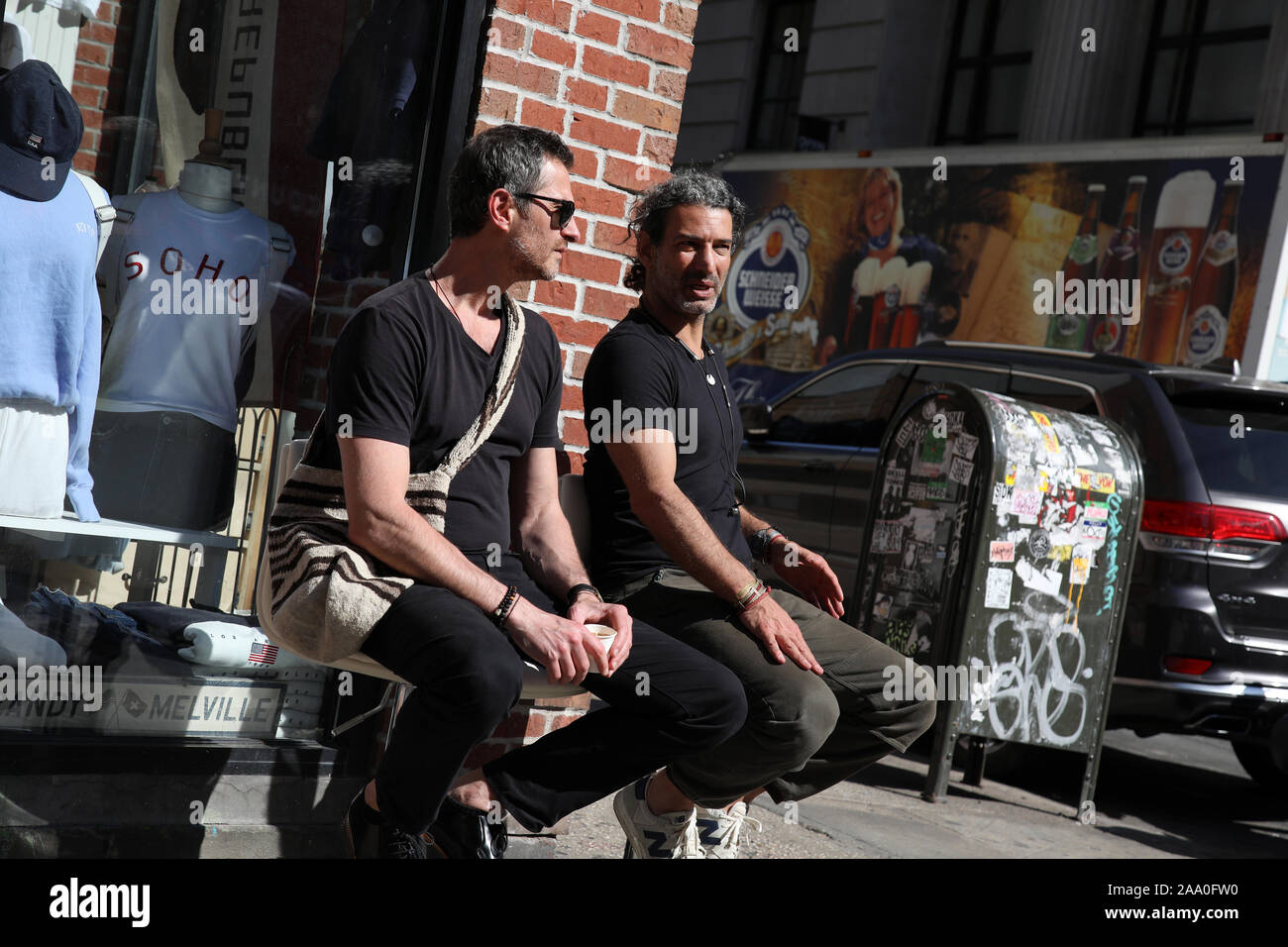 Erwachsene Männer sitzen und sprechen Sie auf der Straße in Nolita, Manhattan, New York. Stockfoto