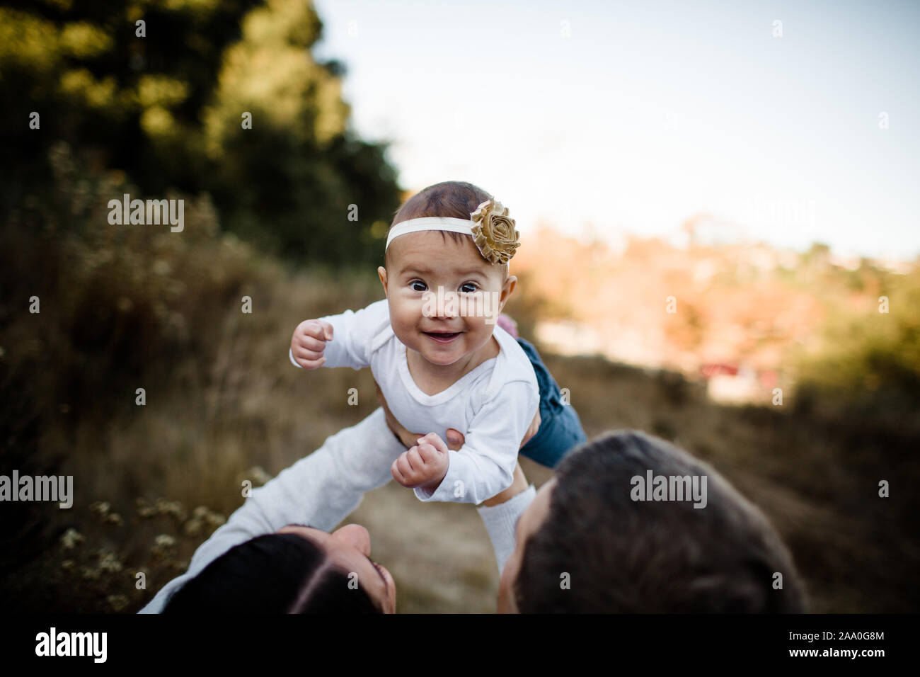 Mom Anheben Tochter als Baby lächelt Kamera Stockfoto