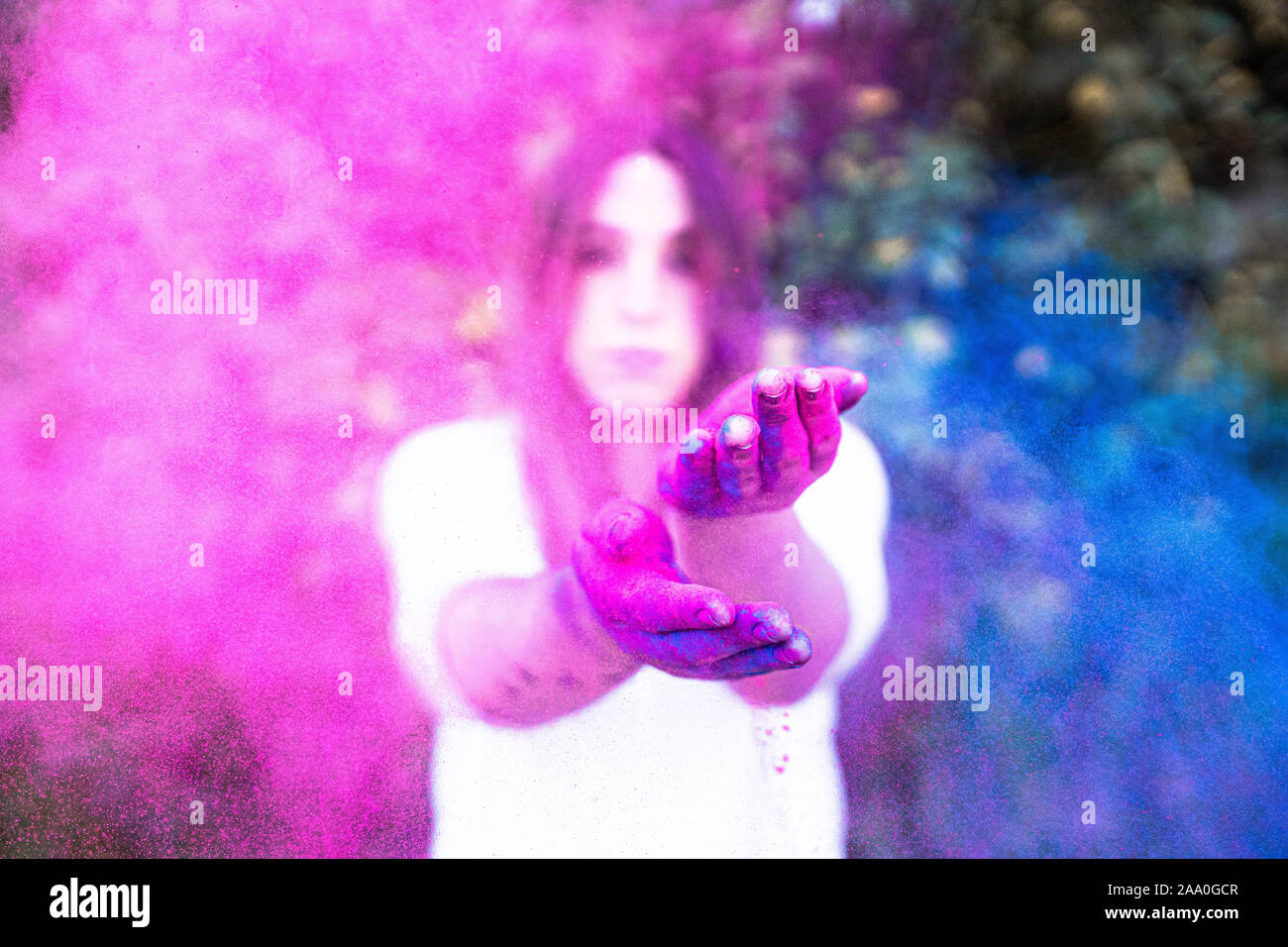 Junge Frau spielt mit Farben, die Schaffung einer Farbe Explosion mit Blau. Stockfoto