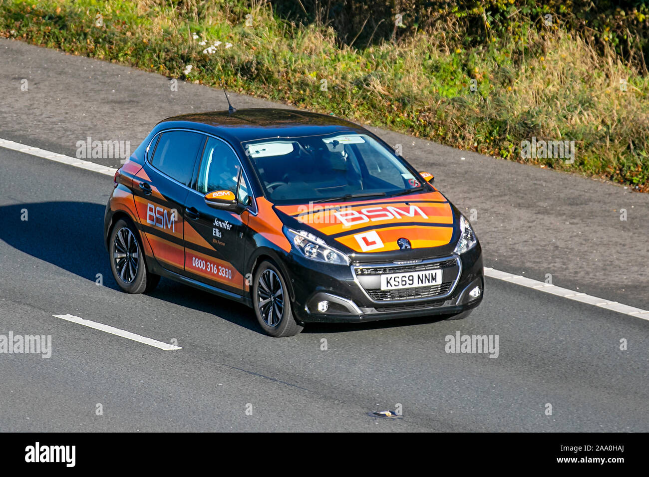 2019 Black Peugeot 208 Tech Edition S/S; BSM Kursteilnehmer Autobahnschulung, unter Einweisung, Fahrschule, Fahrer, Autobahnfahrstunden, Zugelassener Fahrlehrer, Unterricht unter Aufsicht, Ausbilder; Kfz-Schilder auf sich bewegenden Fahrzeugen, Fahren von Fahrzeugen auf britischen Straßen, Motoren, Fahren auf der Autobahn M6 Stockfoto