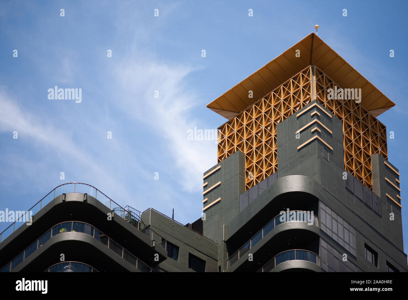 Orange und dunklem Grau moderne Apartmentanlage gegen einen blauen Himmel mit dünnen Wolken. Stockfoto
