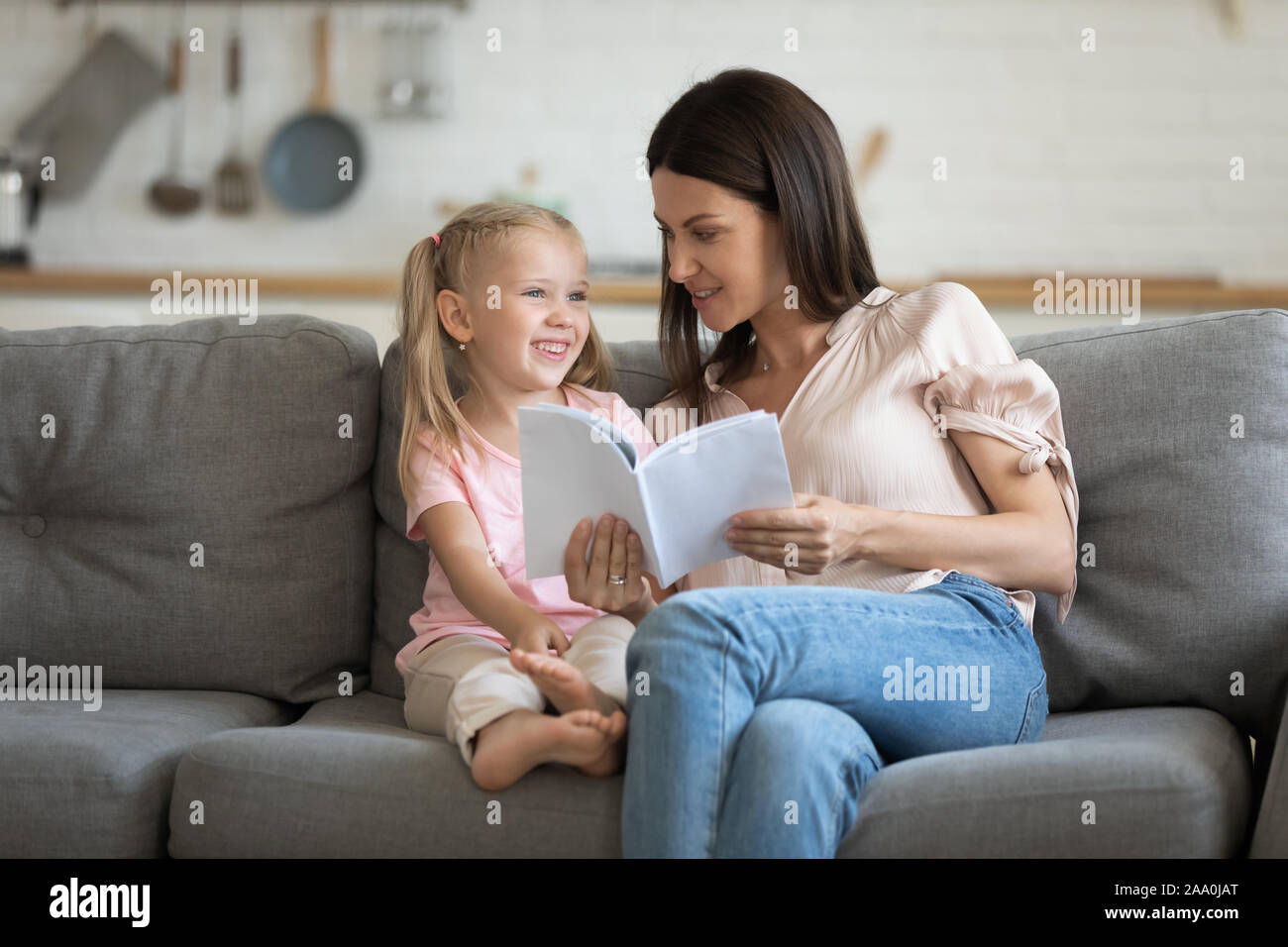 Glückliches Kind Mädchen lesen interessante Bücher mit Mama. Stockfoto