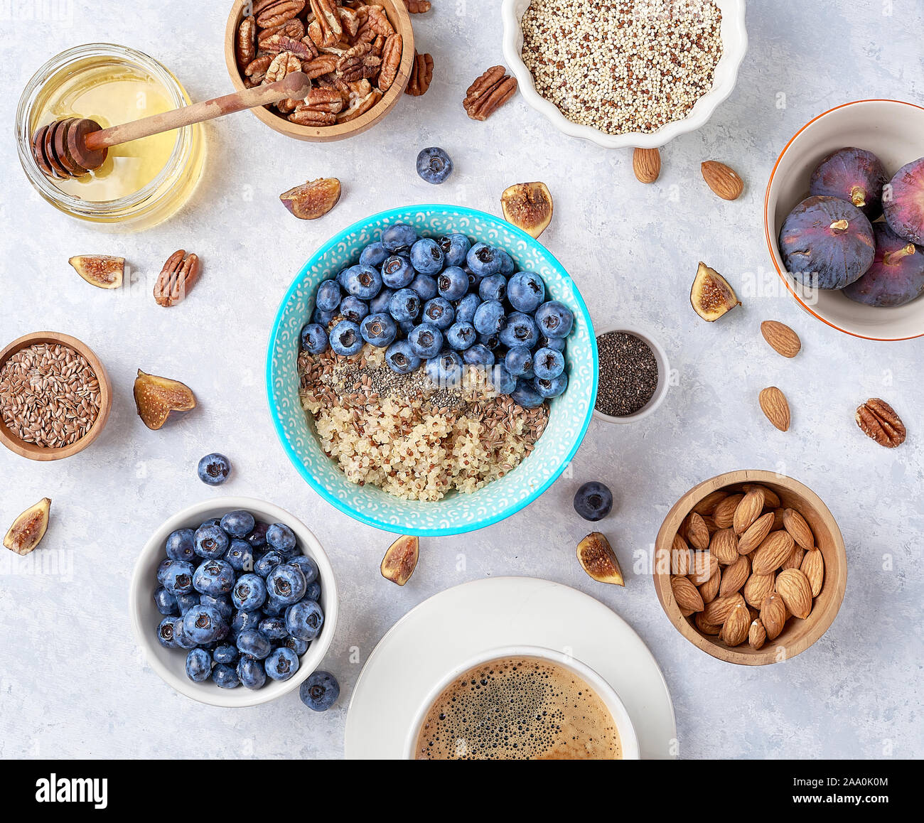 Zutaten für ein gesundes Frühstück, Quinoa mit Blaubeere, Feigen, Honig und Nüssen. Konzept der gesunden Ernährung. Stockfoto