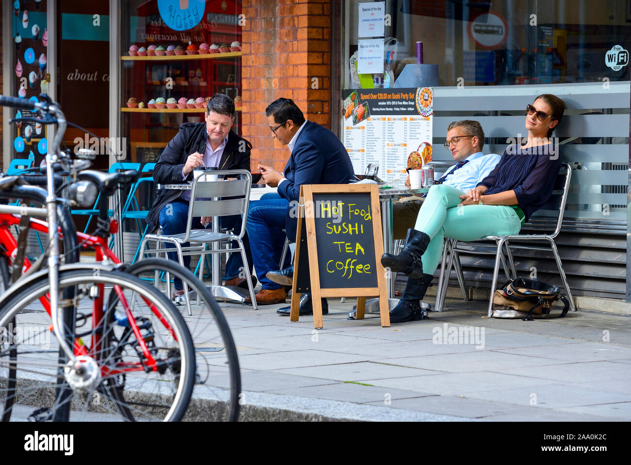 Arbeitskollegen, die Mittagessen essen und draußen Kaffee trinken, an einem Westminster Lunch Spot. Stockfoto