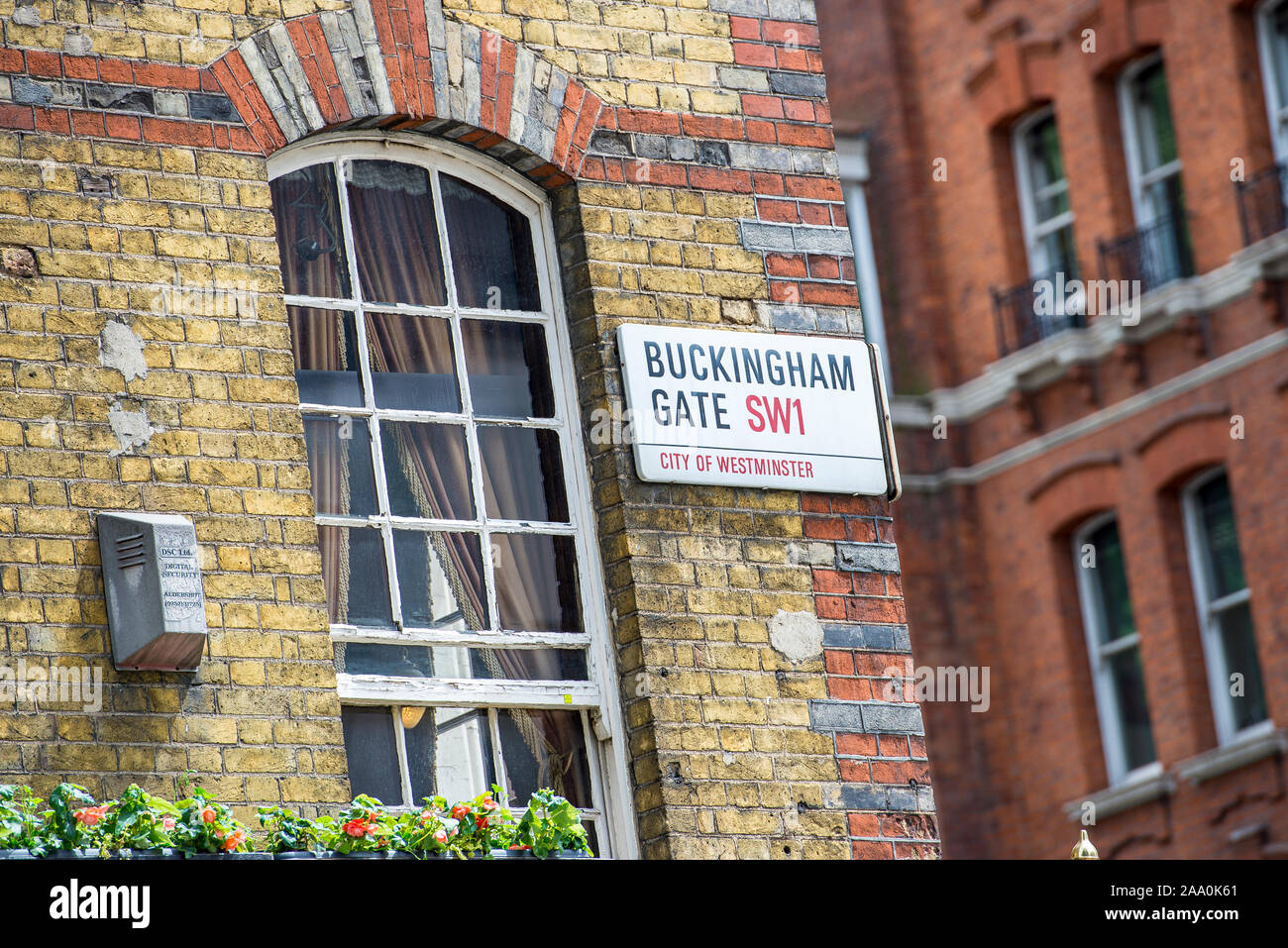 Straßenschild Buckingham Gate an der Fassade eines gelben Ziegelbaus in einer Straße in Westminster, London Stockfoto