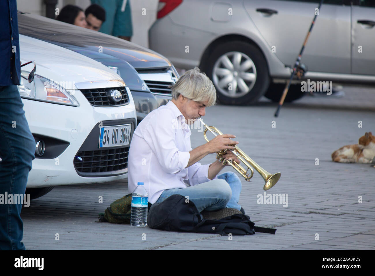Istanbul, Türkei - September -14.2019: Musiker sitzen auf der Straße vor dem Auto spielt Trompete. Menschen, die zuhören Zahlen. Stockfoto