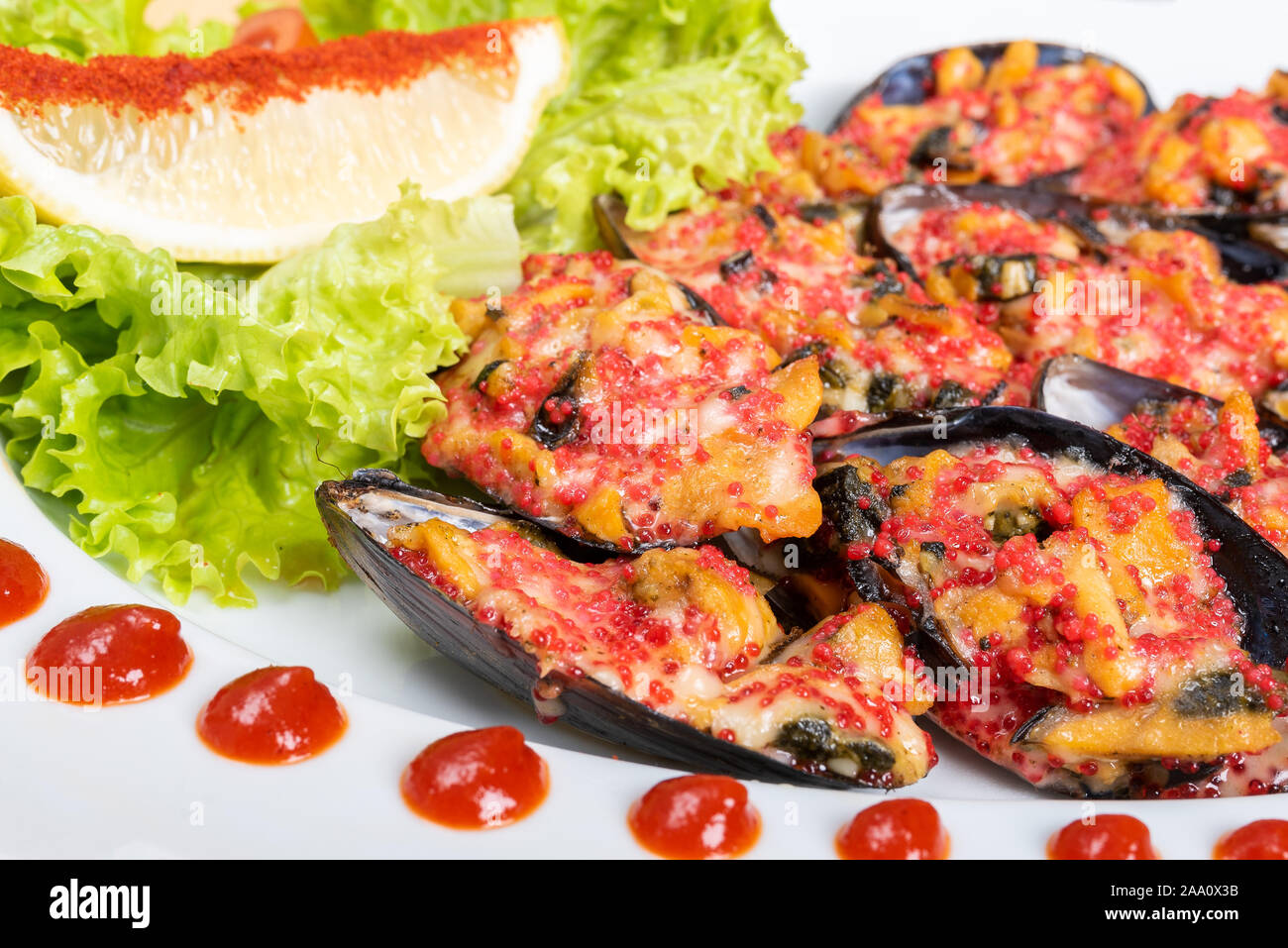 Gebackene Muscheln in Halbschale mit Füllung und Beilage. Stockfoto