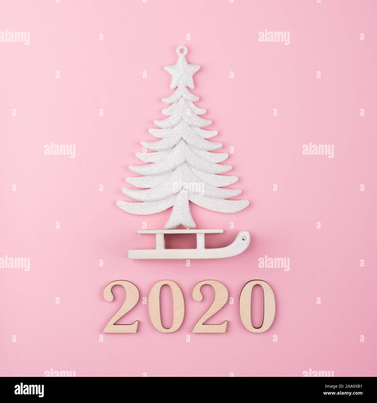 Minimale Weihnachten Zusammensetzung, Baum und Schlitten auf einem rosa Hintergrund. 2020 Jahr. Flach, Ansicht von oben Stockfoto