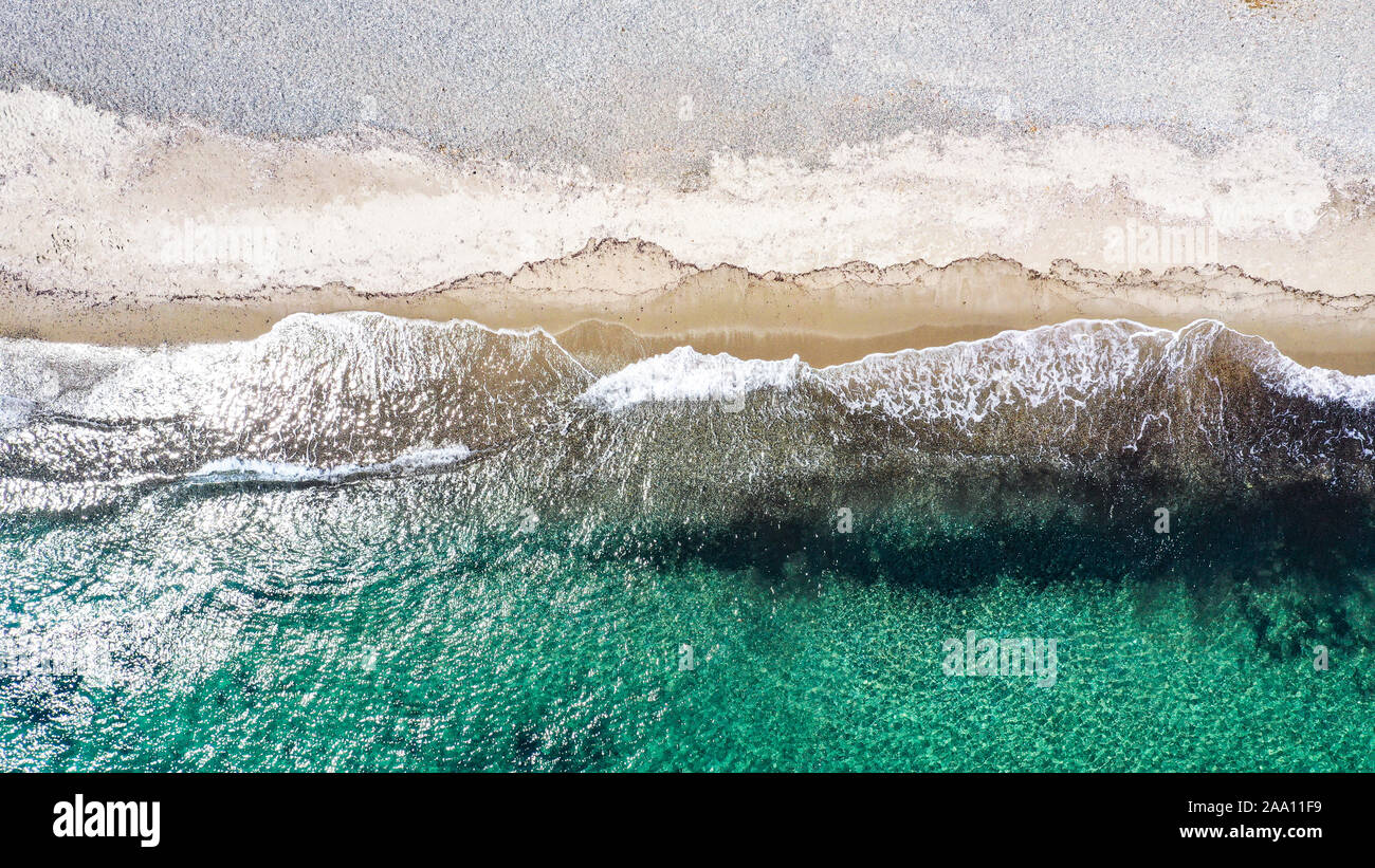 Antenne top-down-Ansicht mit Drone eines mediterranen Strand mit klarem, blauen Wasser kleine Sand und Wellen Stockfoto