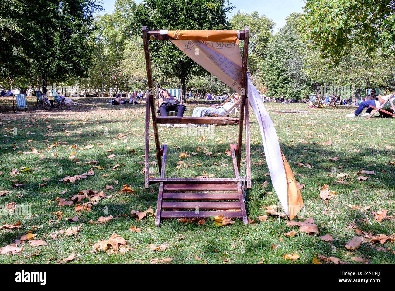 Menschen entspannend auf Liegestühlen in der St. James's Park, London, UK Stockfoto