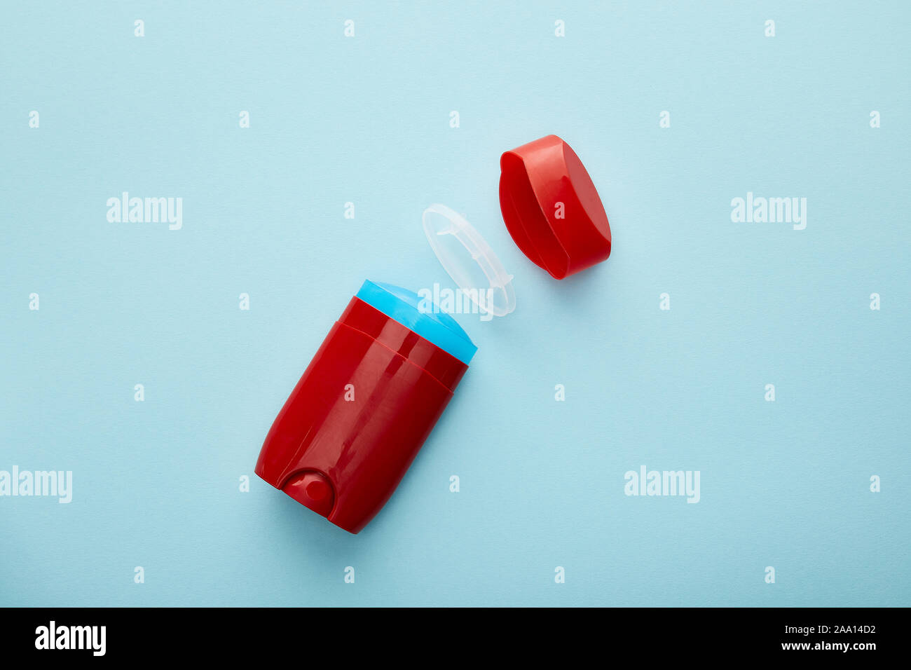 Blick von oben auf die rote Roll-on-Flasche Deo auf blauem Hintergrund Stockfoto