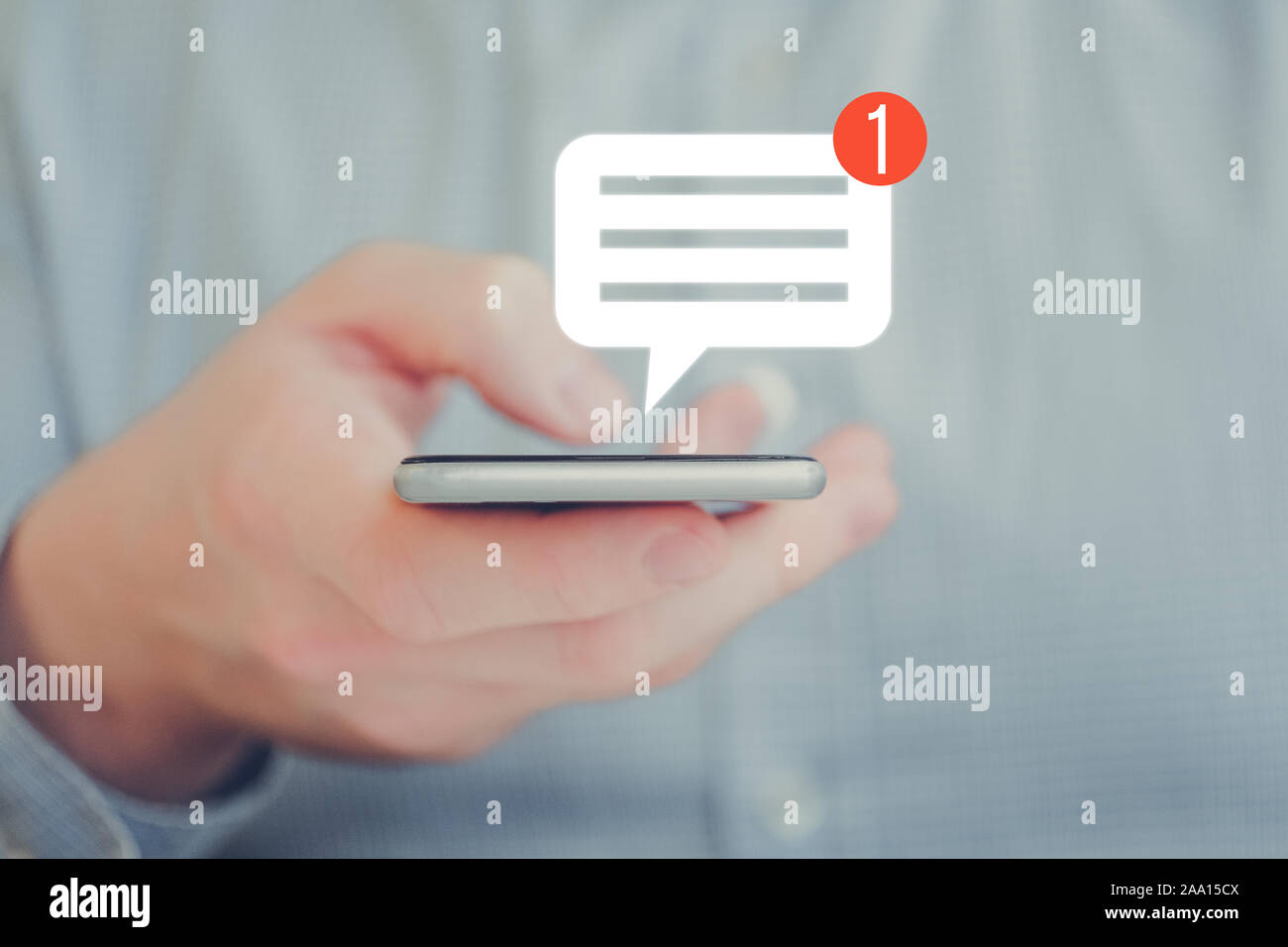 Ein Mann in einem T-Shirt hält ein Smartphone mit seiner Hand. Abstrakte Benachrichtigung Symbol. Social Networking Konzept. Close Up. Stockfoto