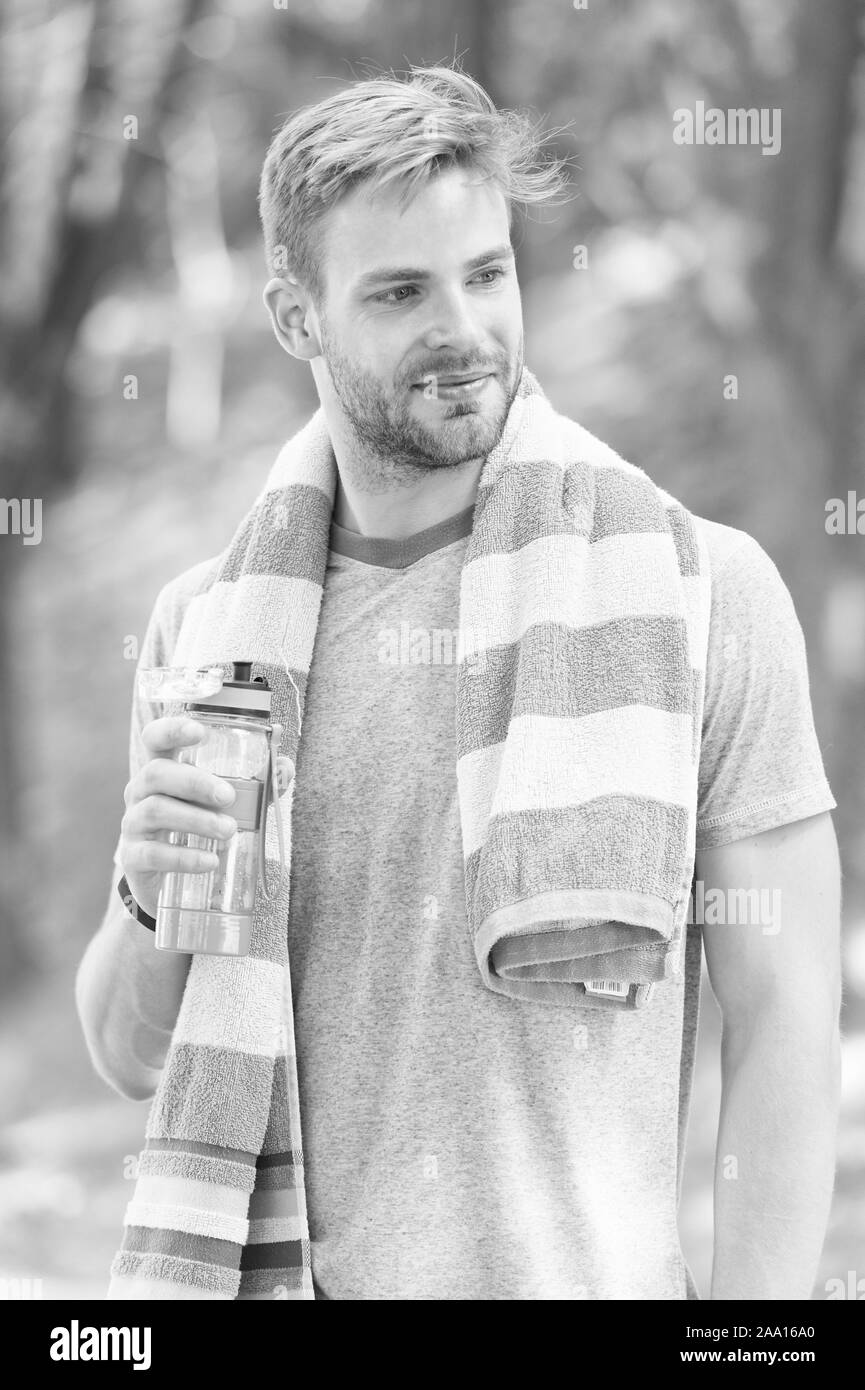 Ihren Durst gehorchen. Durstige Sportler. Der bärtige Mann mit Flasche Trinkwasser, um seinen Durst zu stillen. Durstlöschend beim Sport oder Fitness outdoor. Durst und Austrocknung. Stockfoto