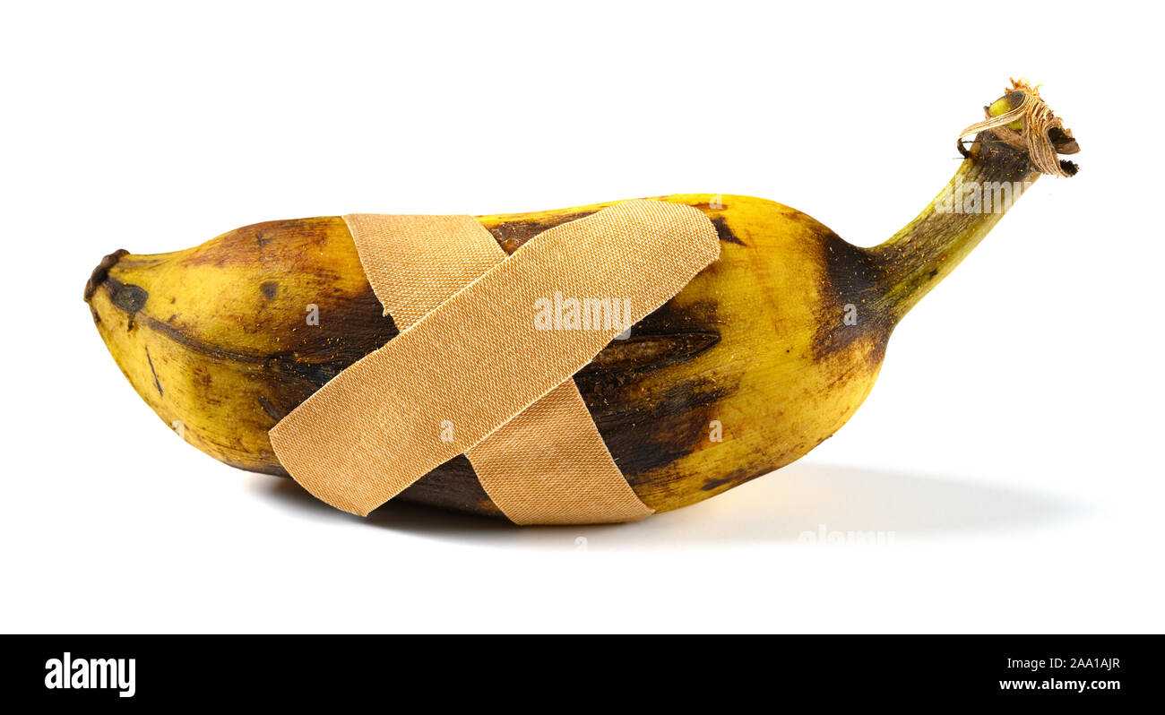 Überreif und rissig Banane mit Gips auf weißem Hintergrund Stockfoto