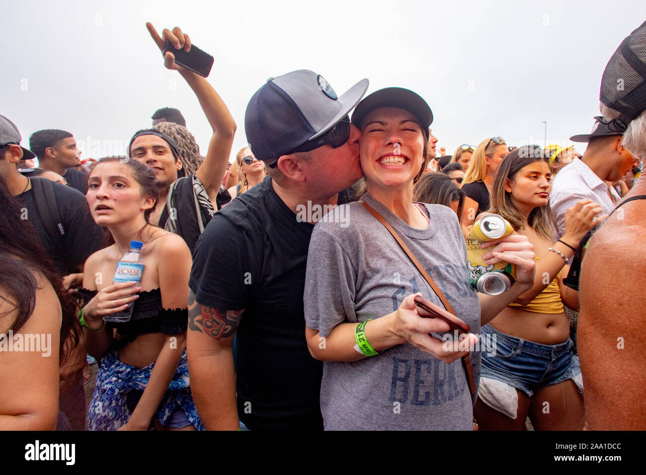 Enthusiastisch multirassischen Männer und Frauen jubeln und Kuss an einer im Konzert in Huntington Beach, CA. Stockfoto