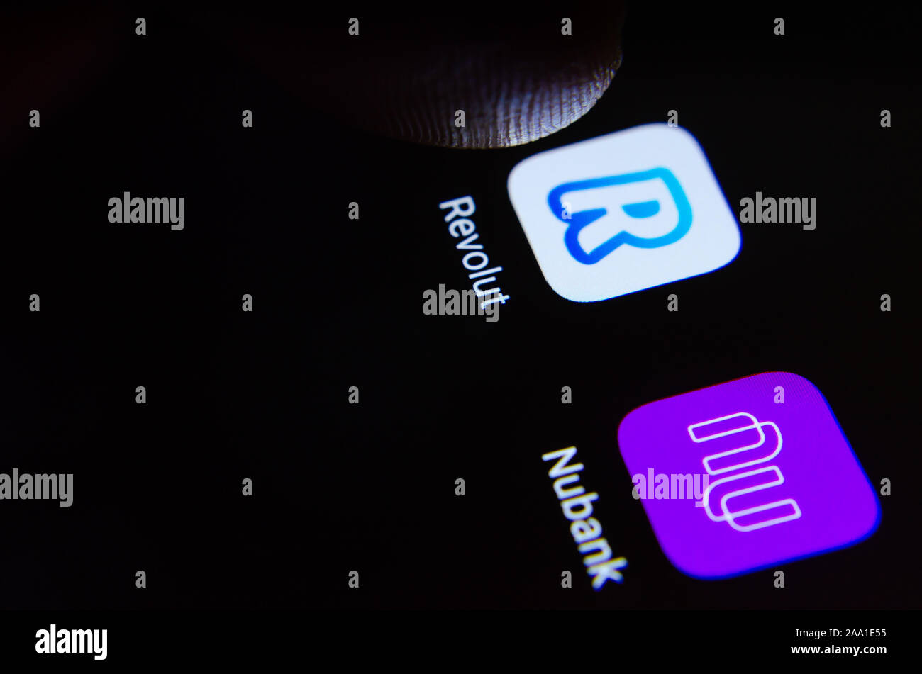 Revolut und Nubank Bank App Icons auf dem Bildschirm mit dem Finger berühren. Stockfoto