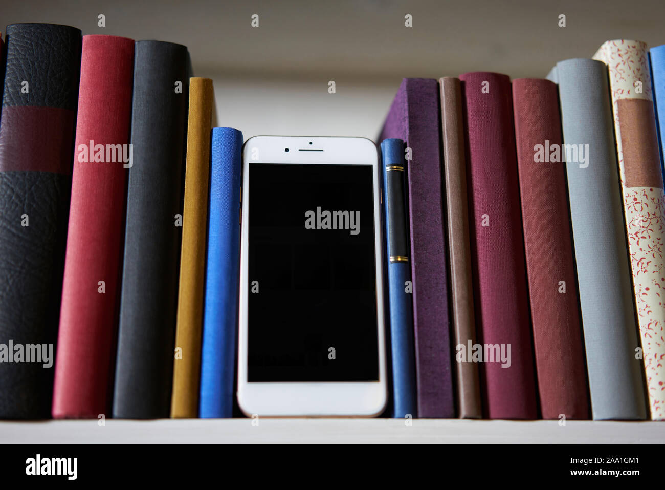 Smartphone stehend zwischen exakter Bücher Stockfoto