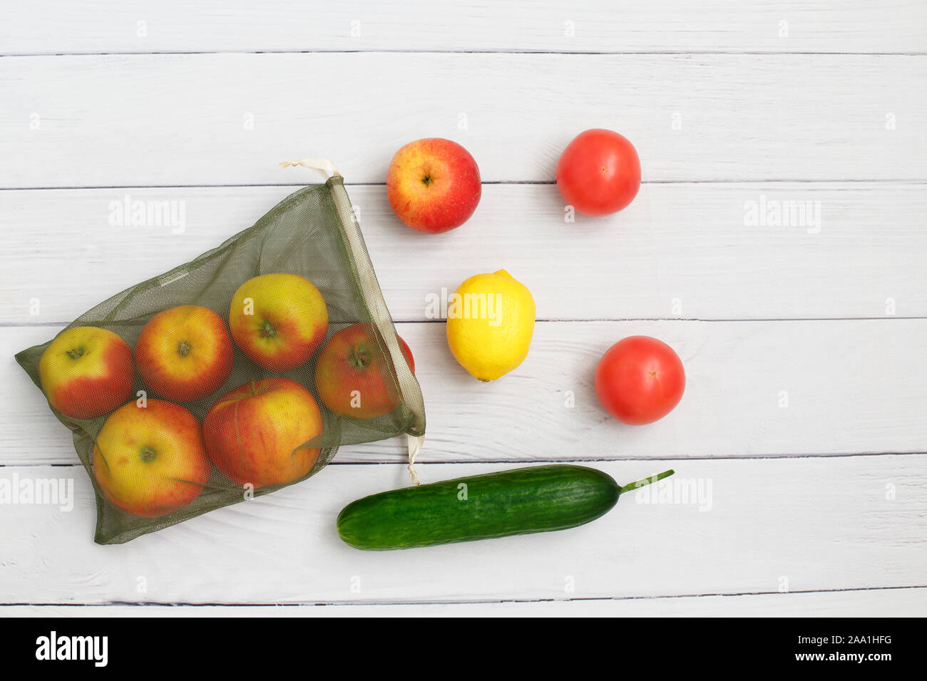 Gemüse und Obst auf wiederverwendbare umweltfreundliche Netzbeutel auf Holz- Hintergrund. Stop Umweltverschmutzung. Null Abfall einkaufen. Ökologische Konzept. Stockfoto