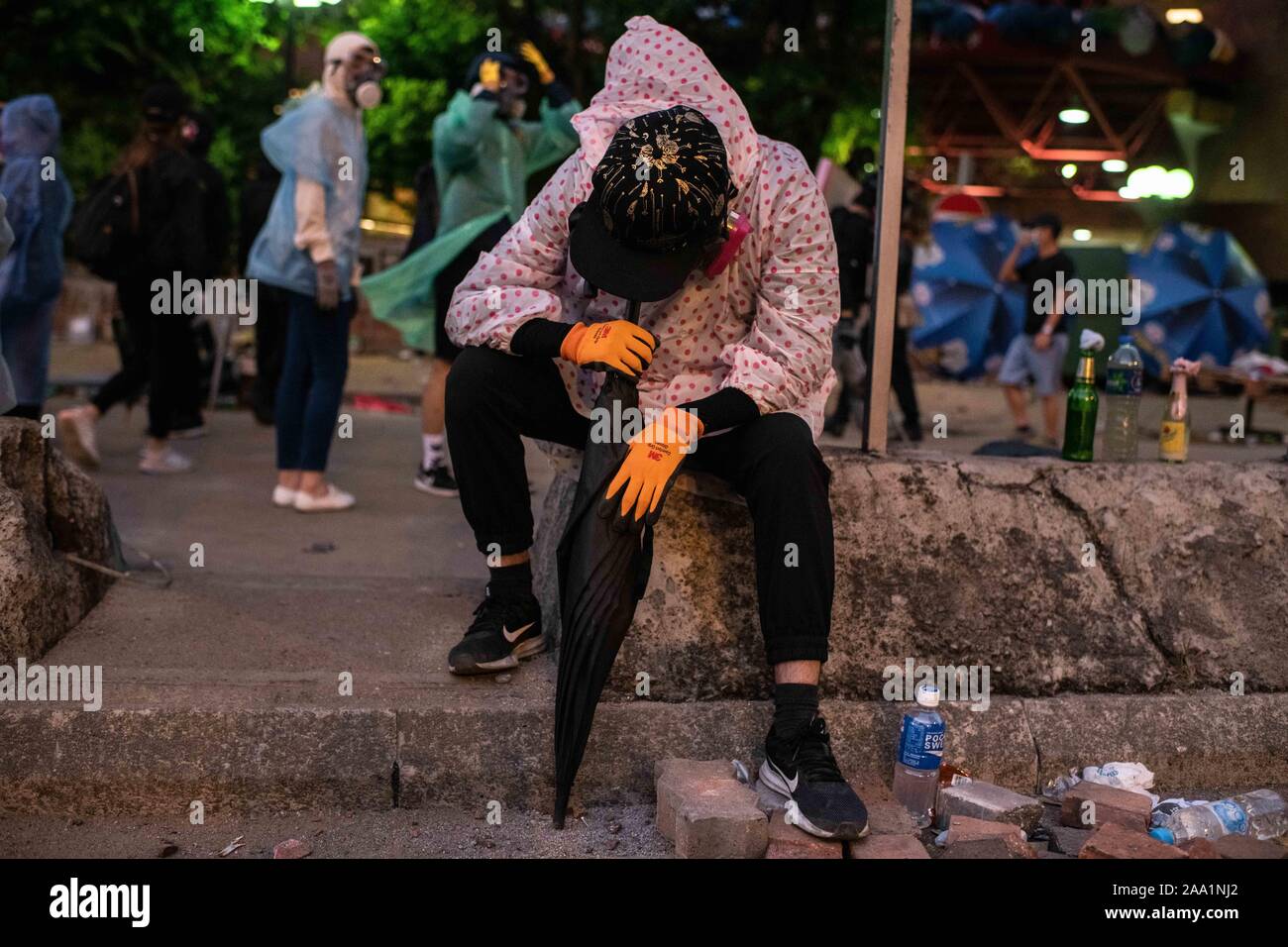 Hongkong, China. 17. Nov, 2019. Eine Demonstrantin liegt mit seinem Gesicht durch einen Regenschirm bei den Auseinandersetzungen unterstützt. Hong Kong Polizei Polytechnische Universität während der heftigen Auseinandersetzungen umgeben. Auseinandersetzungen zwischen Demonstranten und Polizisten weiter um die Polytechnische Universität von den ganzen Tag auszubrechen. Polizei verwendet die Wasserwerfer, Tränengas und Gummigeschossen, während Demonstranten mit Benzinbomben und Ziegeln reagiert. Die meisten der Kämpfe konzentriert an der Kreuzung vor dem Haupteingang der Schule. Credit: SOPA Images Limited/Alamy leben Nachrichten Stockfoto