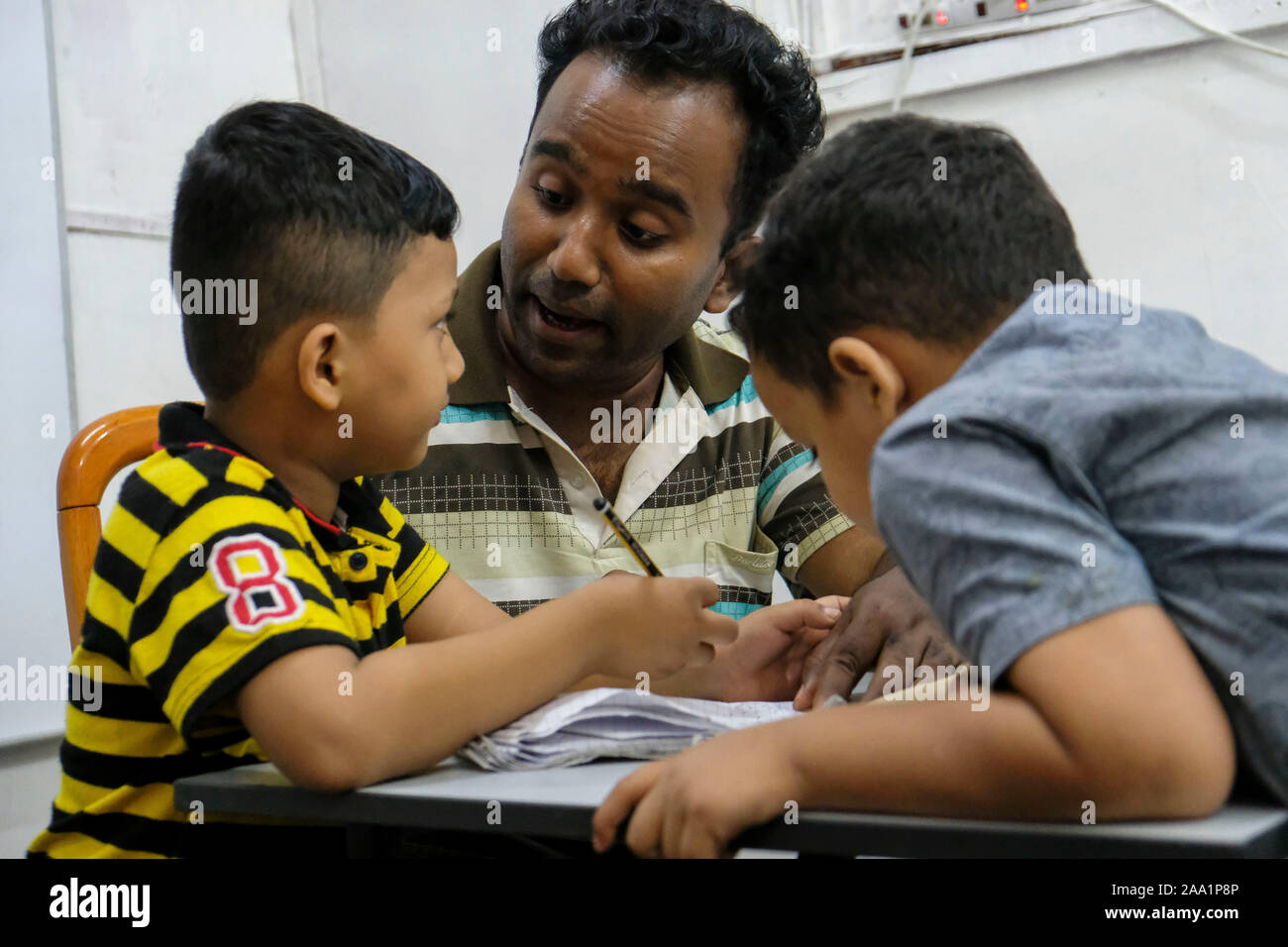 Ein freiwilliger Lehrer mit Kindern in der Klasse an der Akademie. Rohingya English Academy ist ein Learning Center, die freie Bildung auf die Rohingya-flüchtlinge sowohl für Kinder als auch für Erwachsene bietet, wurde es von Saif Ullah ein rohingya Bürger leben in Malaysia und auch ein englischer Tutor an der Akademie Wer erhält keine Unterstützung von der Regierung gegründet. Malaysia hat mehr als 177,690 registrierte Flüchtlinge und Asylsuchenden Rohingya Nach UNHCR-Statistik und 45,470 davon sind Kinder unter 18 Jahren. Stockfoto