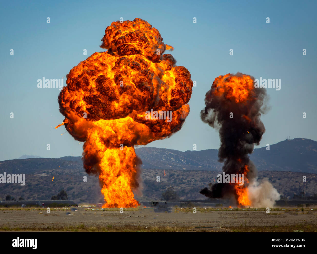 Zwei Spalten von Feuer und Rauch von einem Munition Explosion gegen den blauen Himmel Stockfoto