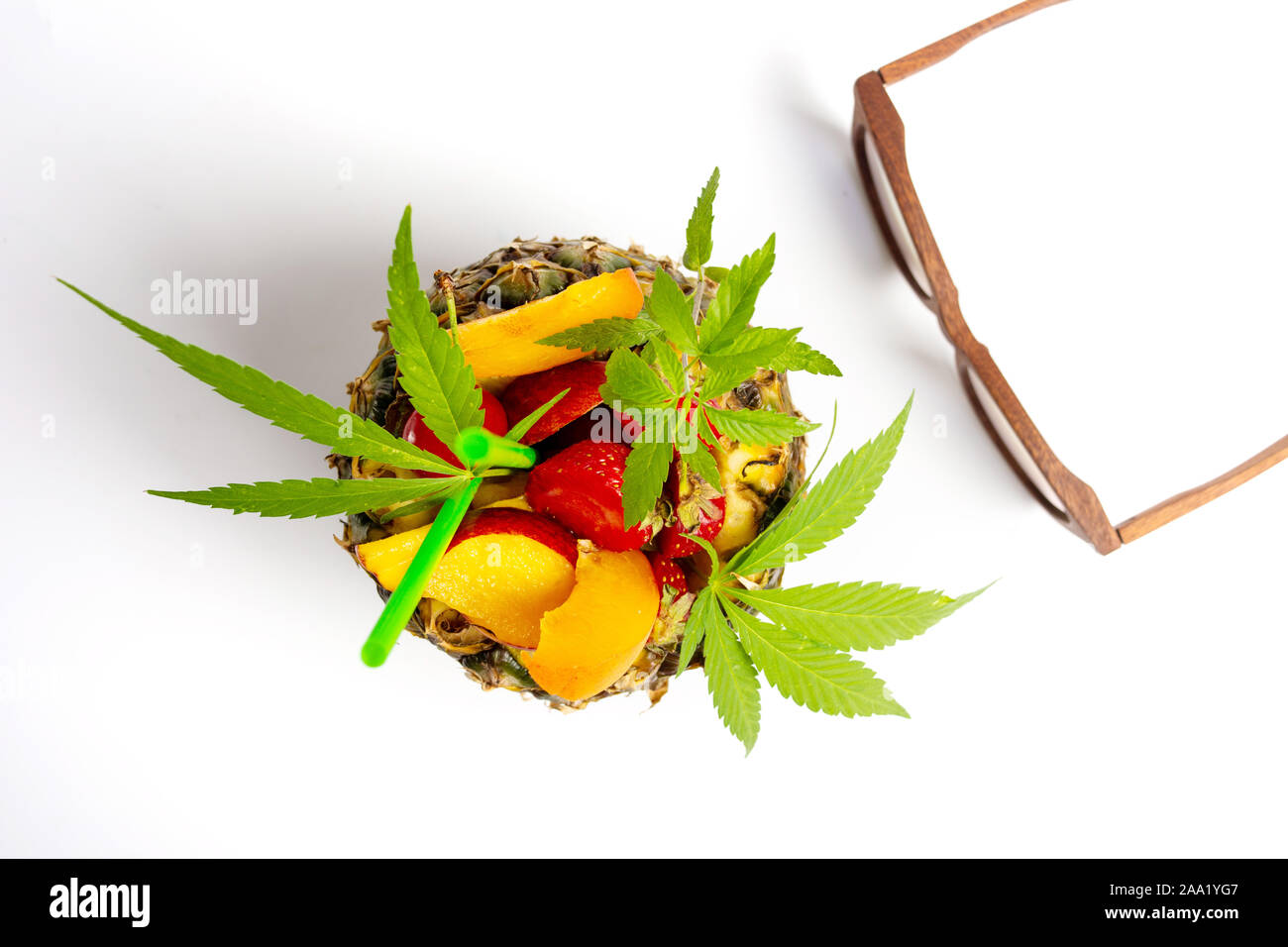 Obstsalat und Orangensaft mit Marihuana Blätter in einer Ananas shell isoliert Stockfoto