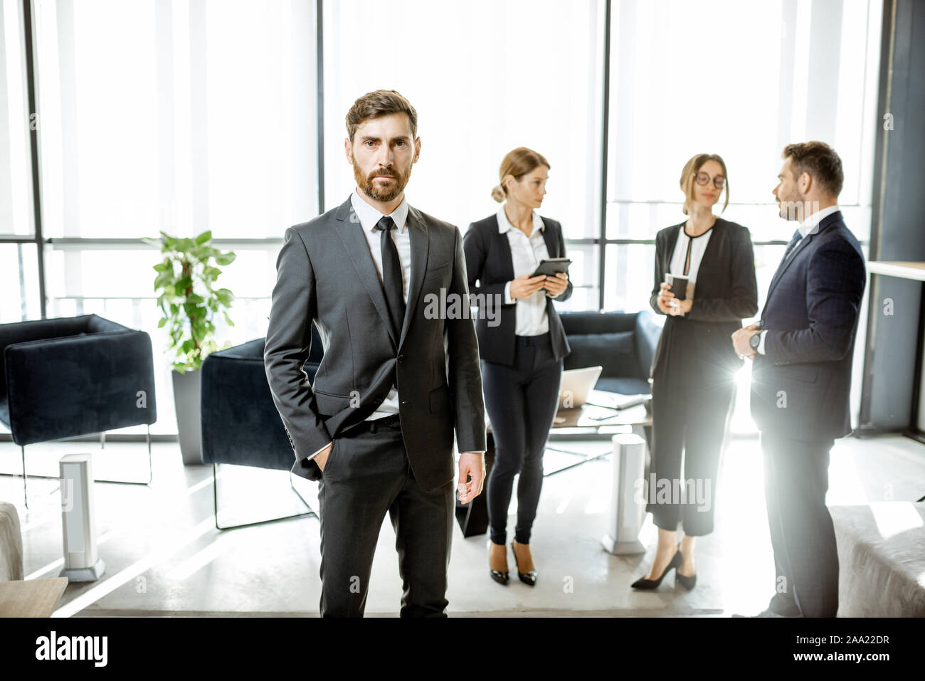 Porträt einer stattlichen weissen Arbeiter vor Business Team im luxuriösen Büro stehend Stockfoto