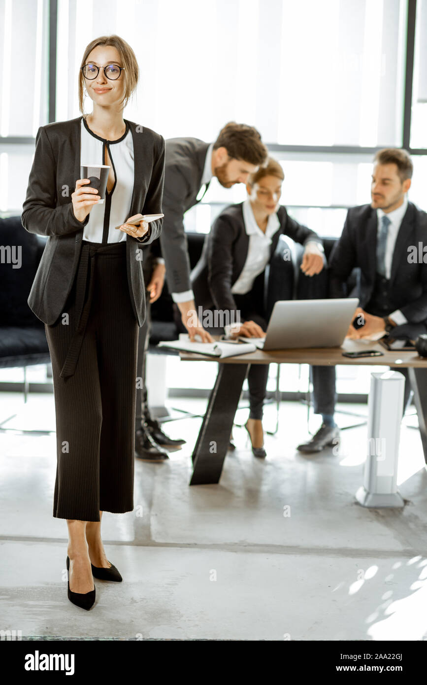 Porträt einer wunderschönen weißen Kragen busines Frau stand vor der Business Team im luxuriösen Büro Stockfoto