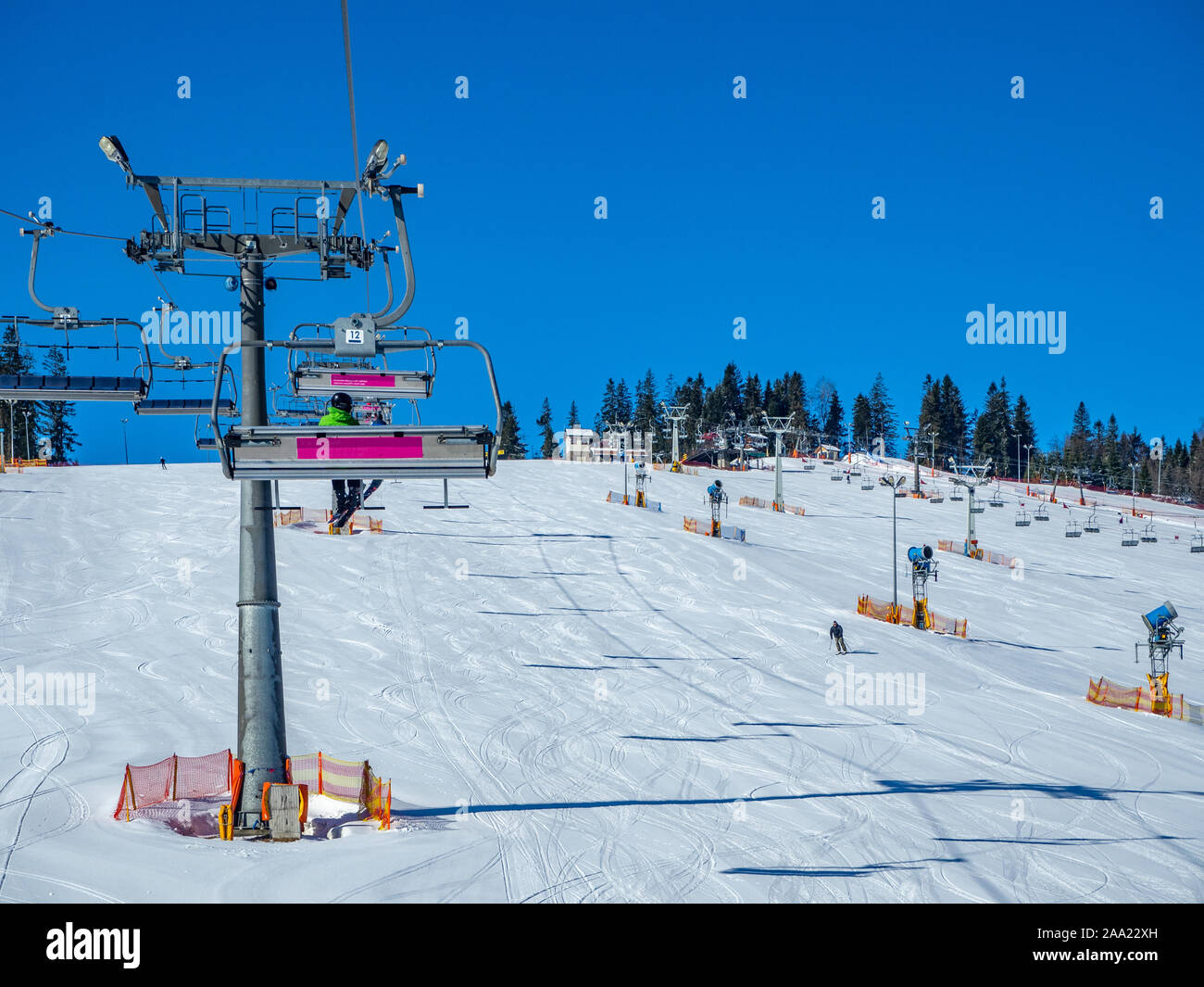 Skipiste mit Liften (Sessel- und Schlepplift) und Kanonen im Bialka Tatrzanska Skigebiet sow in Polen Stockfoto