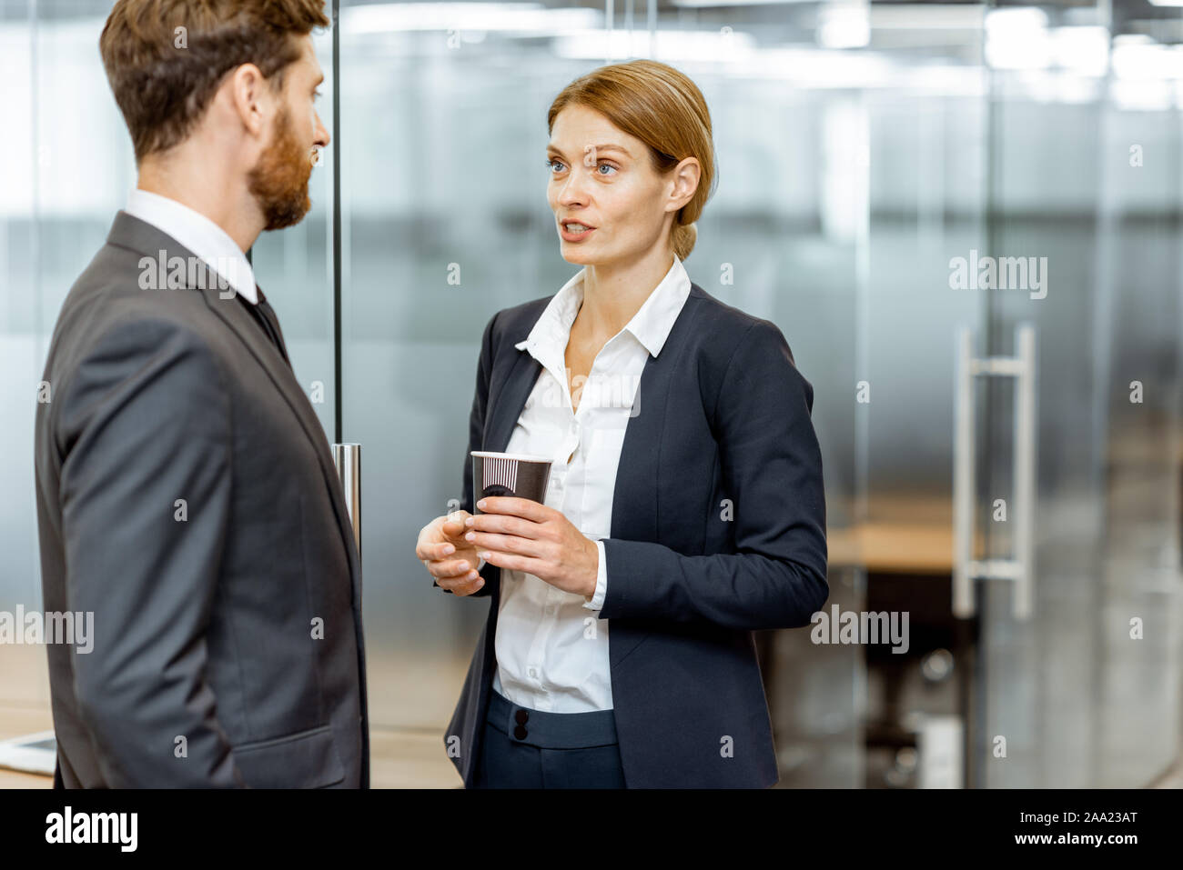 Business Mann und Frau treffen im Flur des modernen Bürogebäude, Angestellte in informelle Diskussion Stockfoto