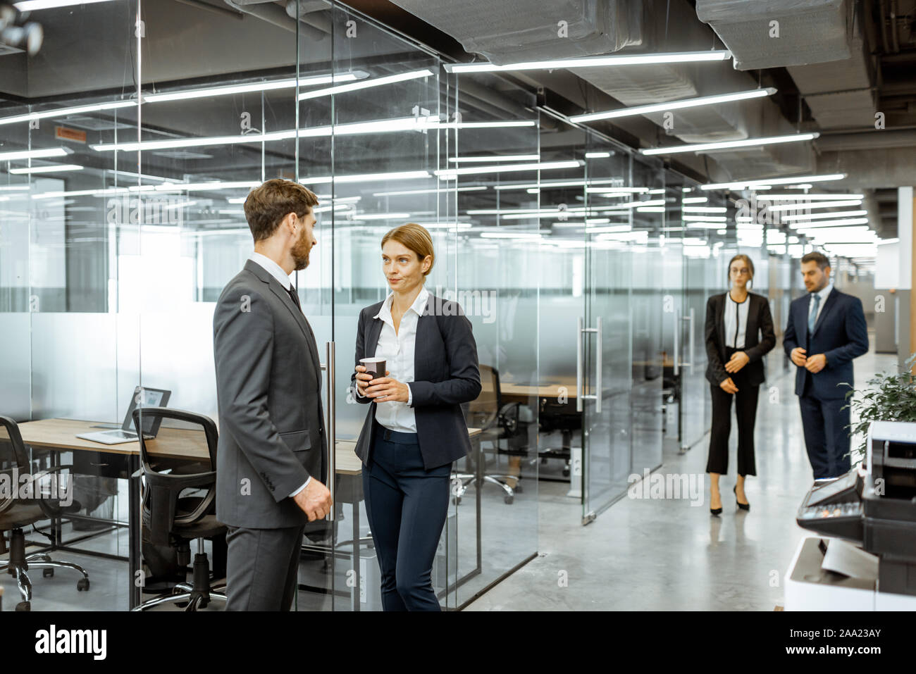 Business Mann und Frau treffen im Flur des modernen Bürogebäude, Angestellte in informelle Diskussion Stockfoto